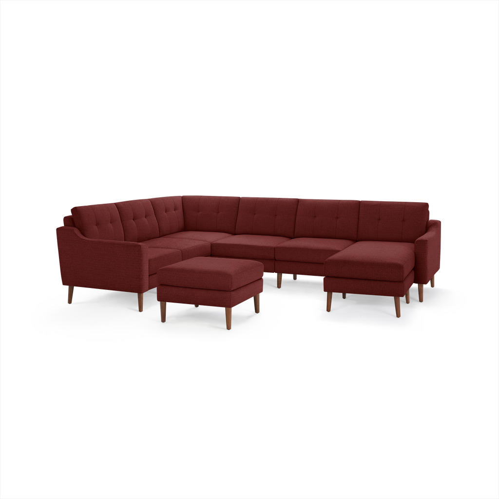 Modern L-shaped sectional sofa and matching ottoman in deep red fabric with tufted cushions and wooden legs.