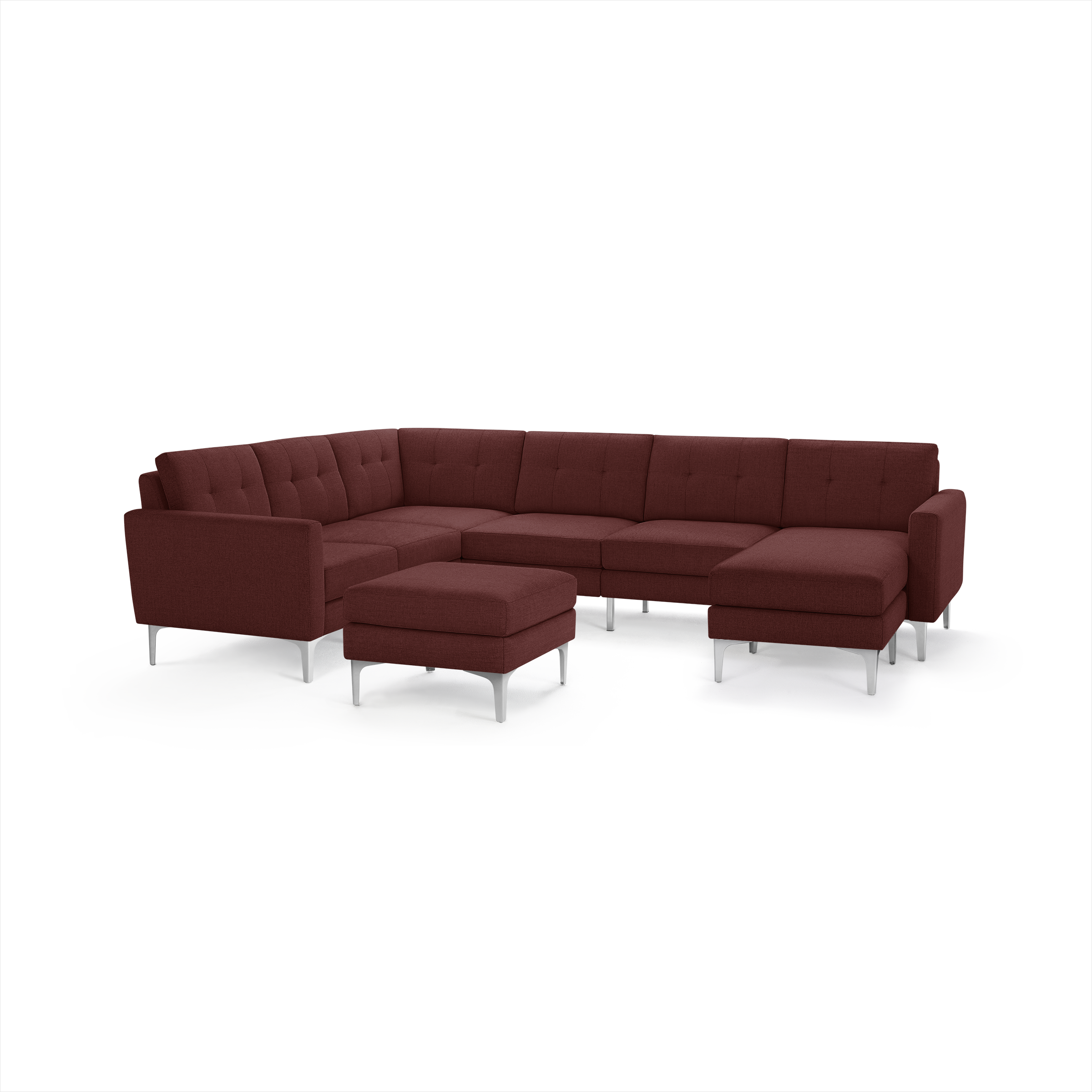 Modern sectional sofa in deep red fabric with tufted backrests, metal legs, and a matching square ottoman.