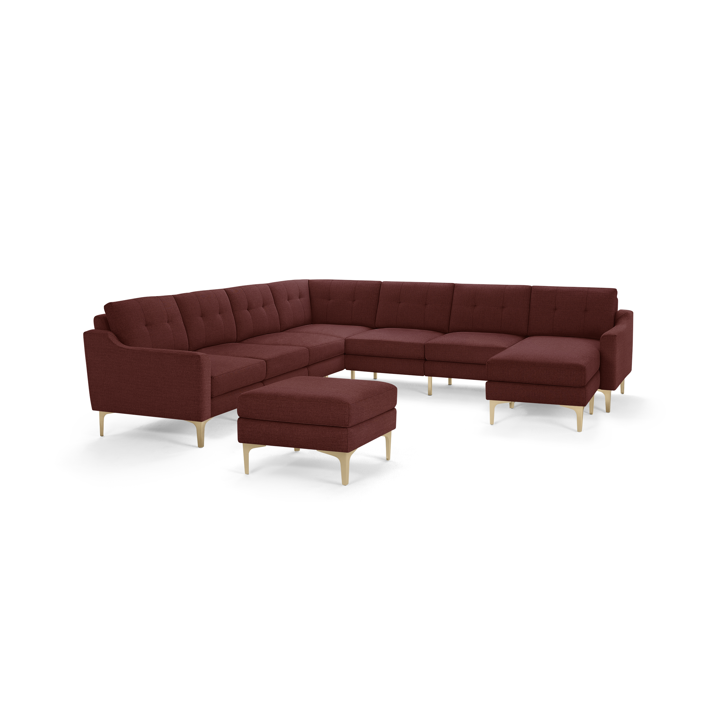 Large modern L-shaped sectional sofa in deep red fabric with button-tufted cushions and light wooden legs, including matching ottoman.