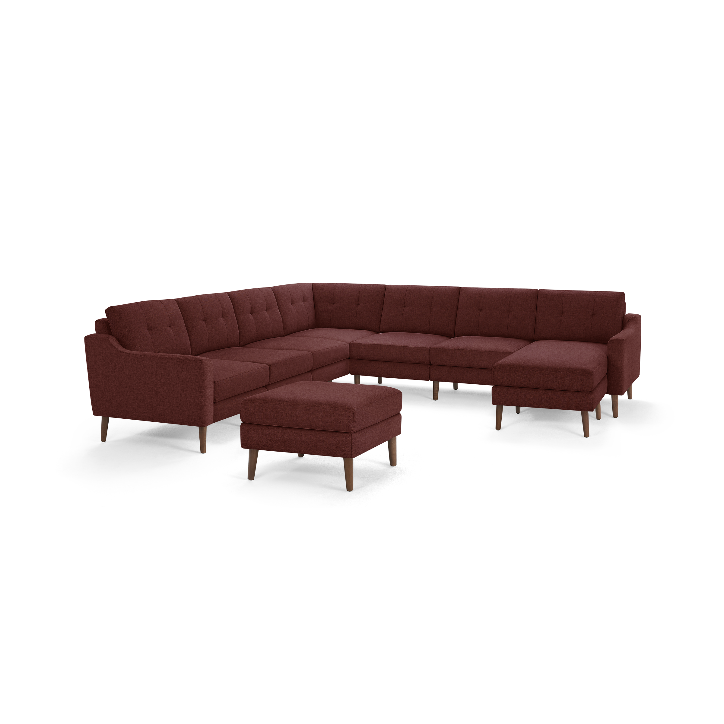 Large L-shaped sectional sofa in deep red fabric with tufted cushions, wooden legs, and matching upholstered ottoman.