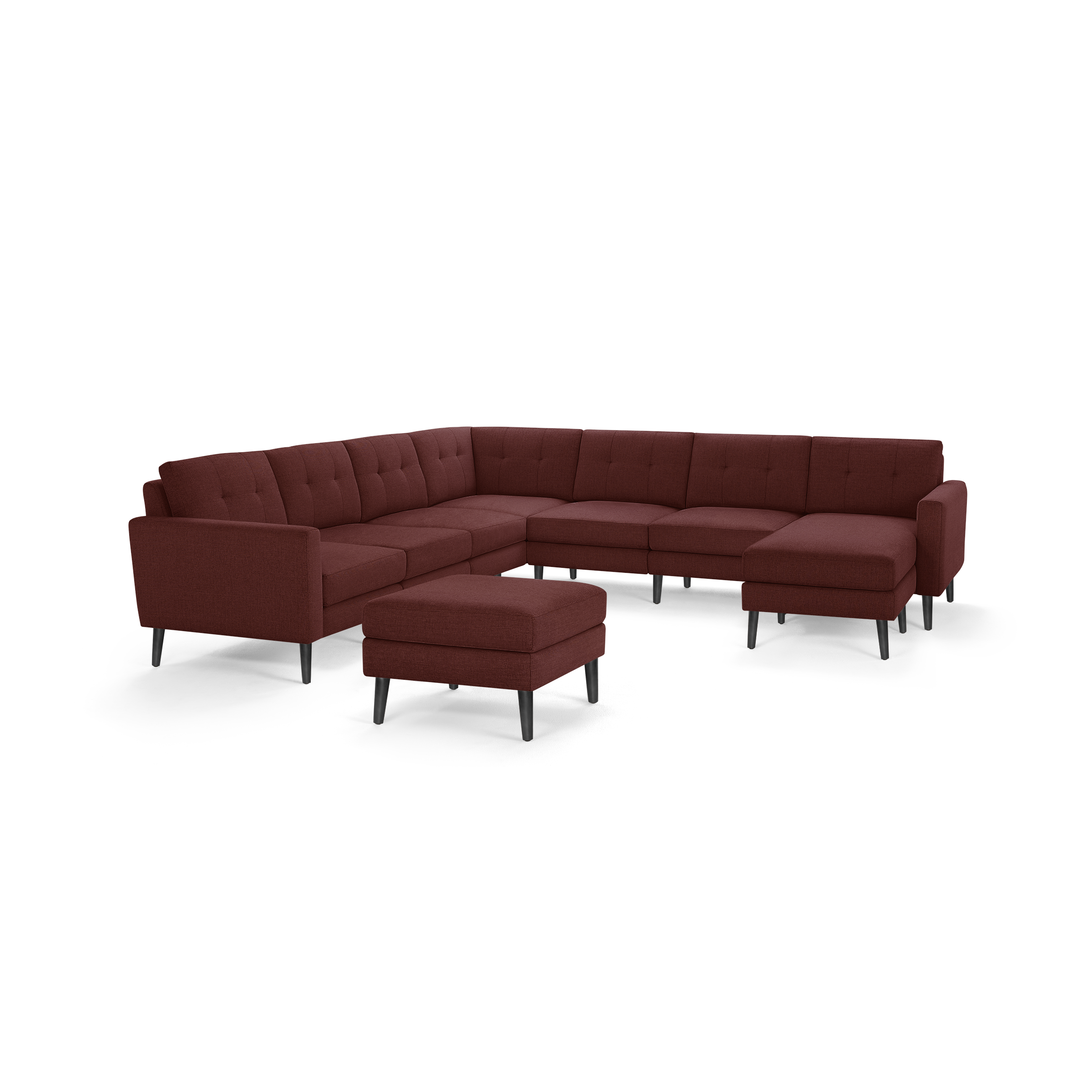 Modern deep red L-shaped sectional sofa with tufted cushions, slim black legs, and a matching ottoman on a white background.