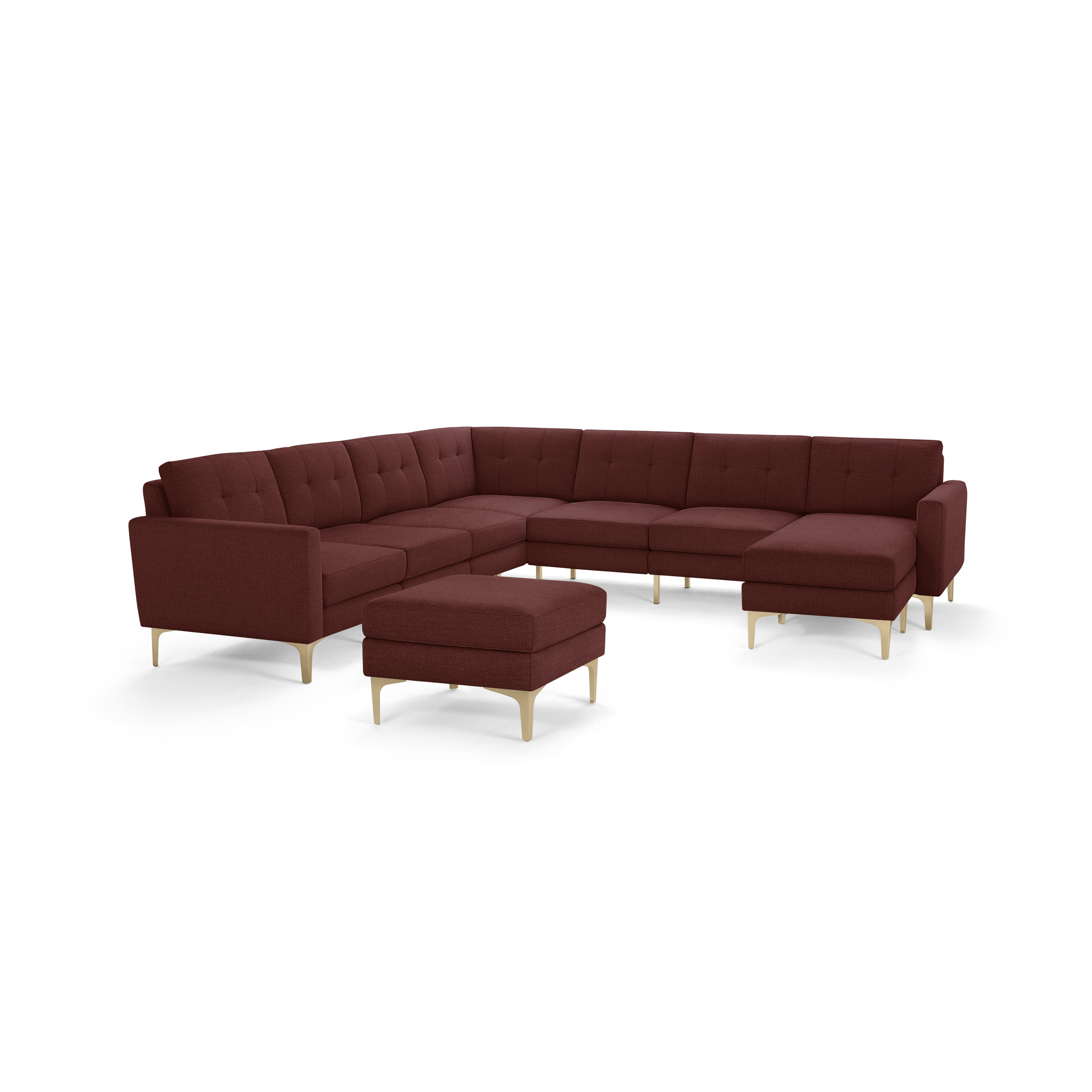 Large U-shaped sectional sofa in rich burgundy fabric with tufted back cushions and light wood legs, including a matching ottoman.
