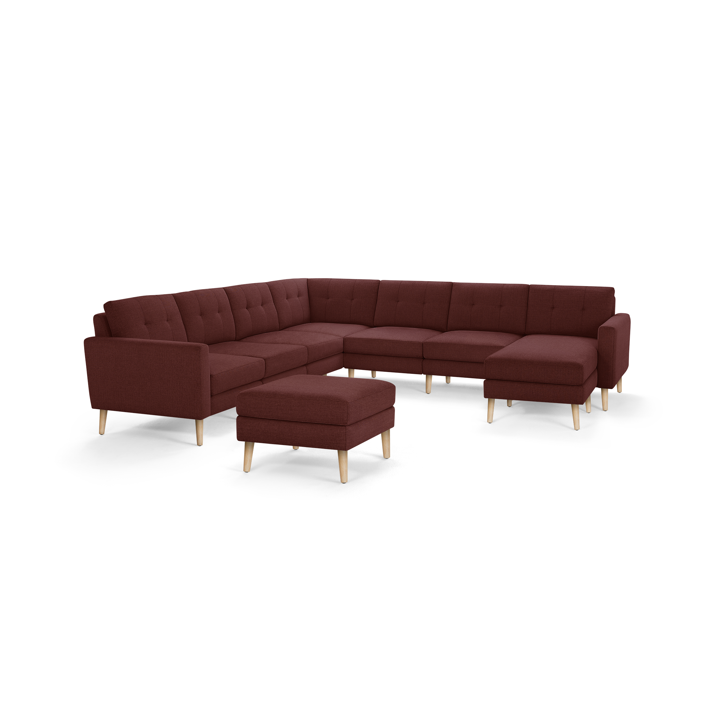 Modern sectional sofa in dark red fabric with tufted cushions, wooden legs, and matching ottoman.