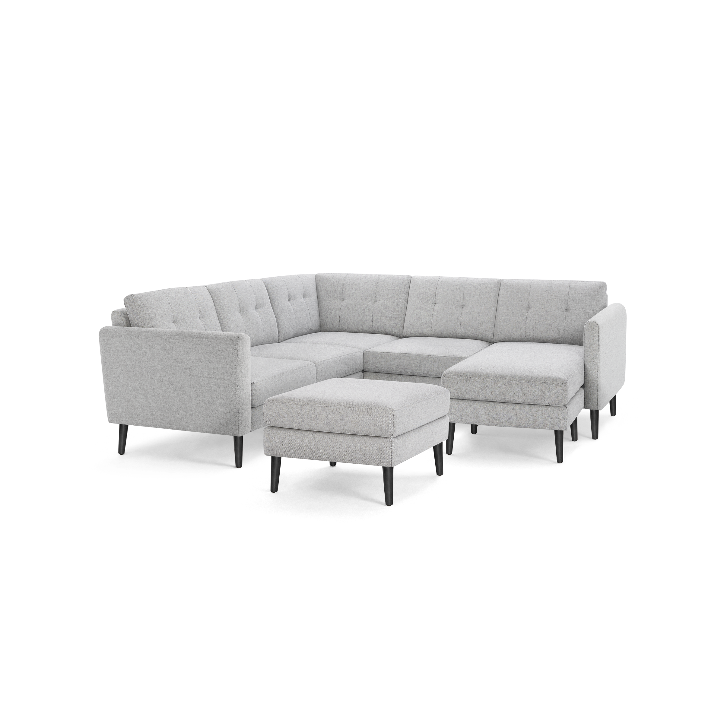 Light gray modern sectional sofa with tufted cushions, three-seater design, chaise lounge, and matching ottoman on black tapered legs.