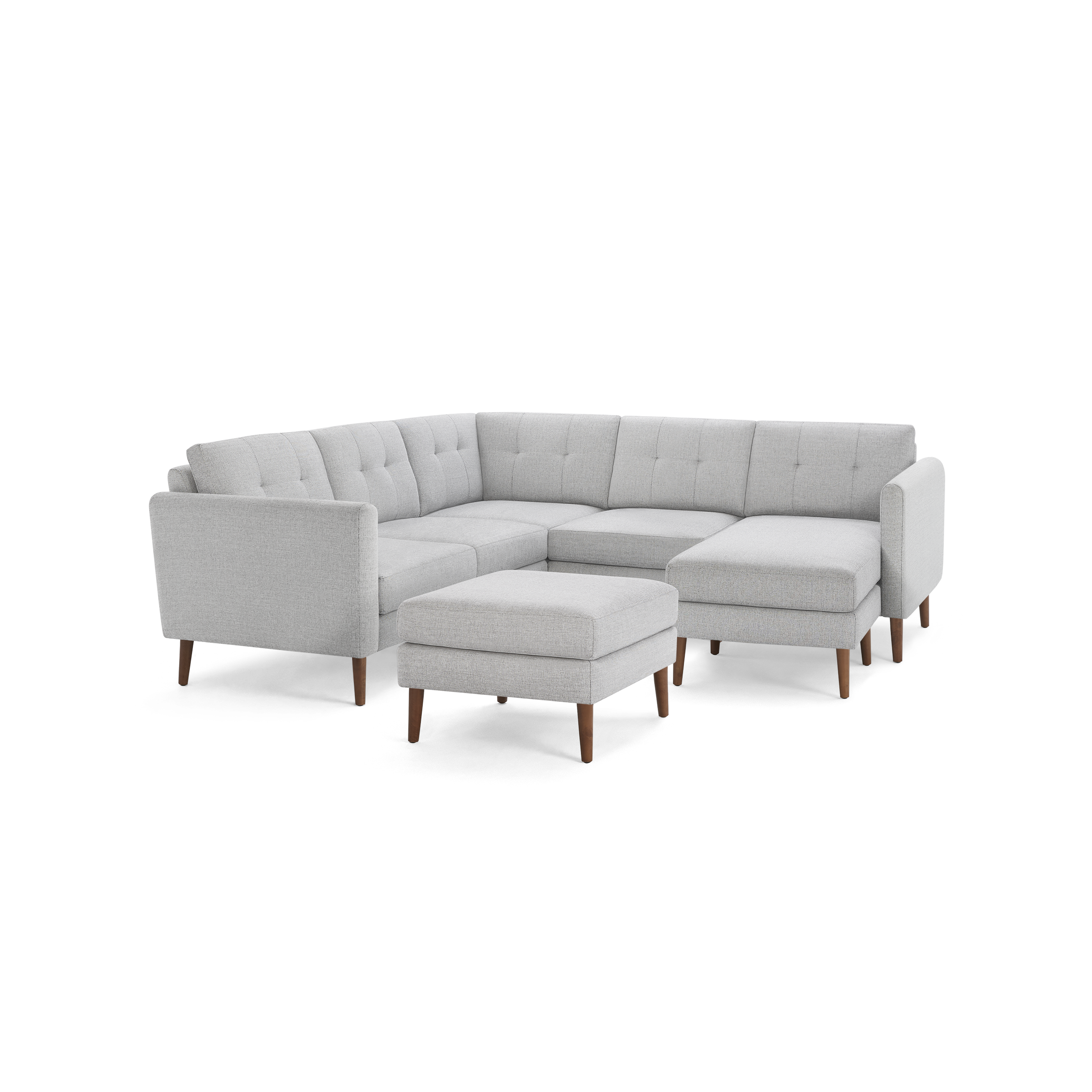 Light gray fabric sectional sofa with tufted back cushions, wooden legs, and matching ottoman on black background.