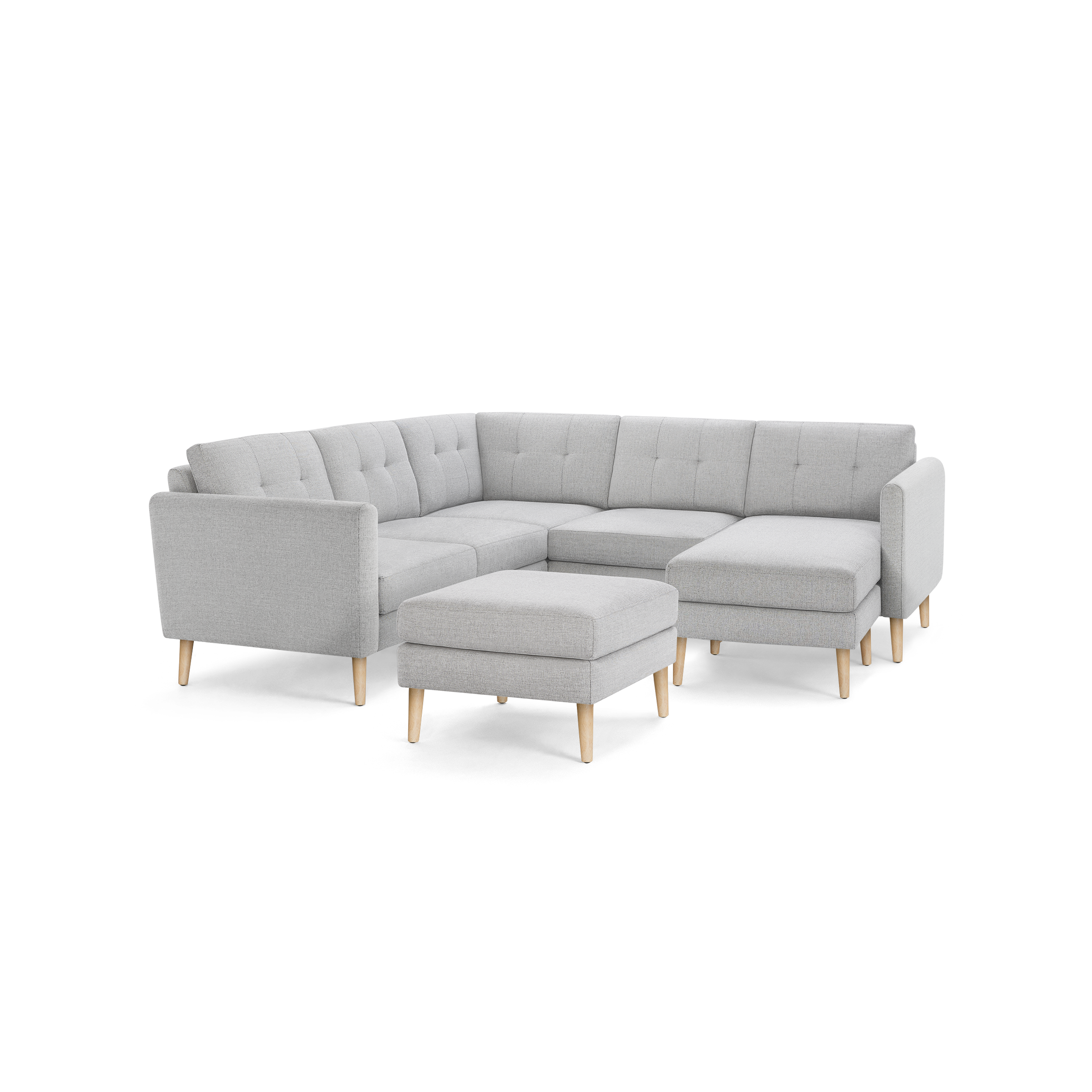 Gray L-shaped sectional sofa with tufted cushions, wooden legs, and a matching ottoman, modern and stylish design.