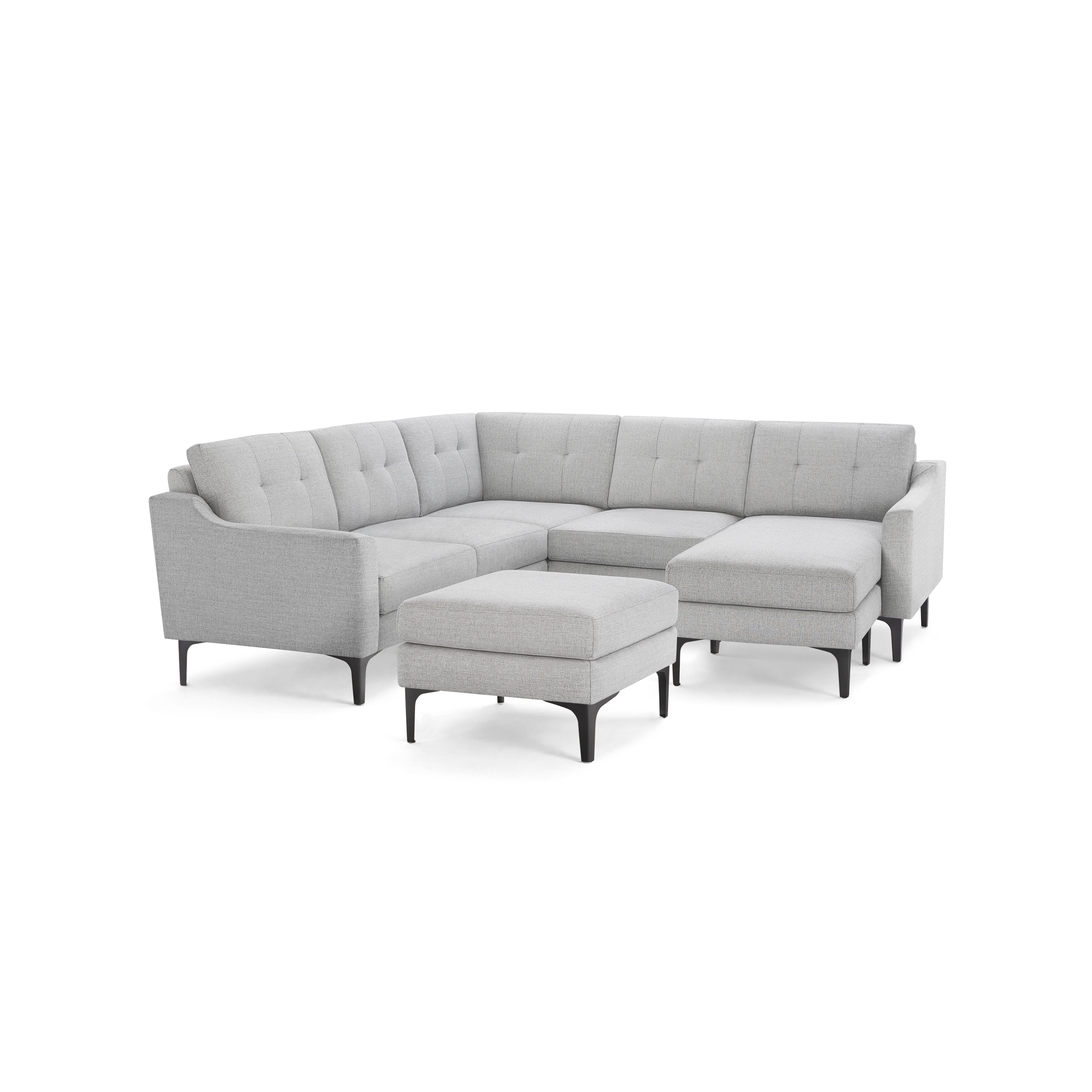 Light gray L-shaped sectional sofa with tufted cushions and matching ottoman, featuring slim black legs.