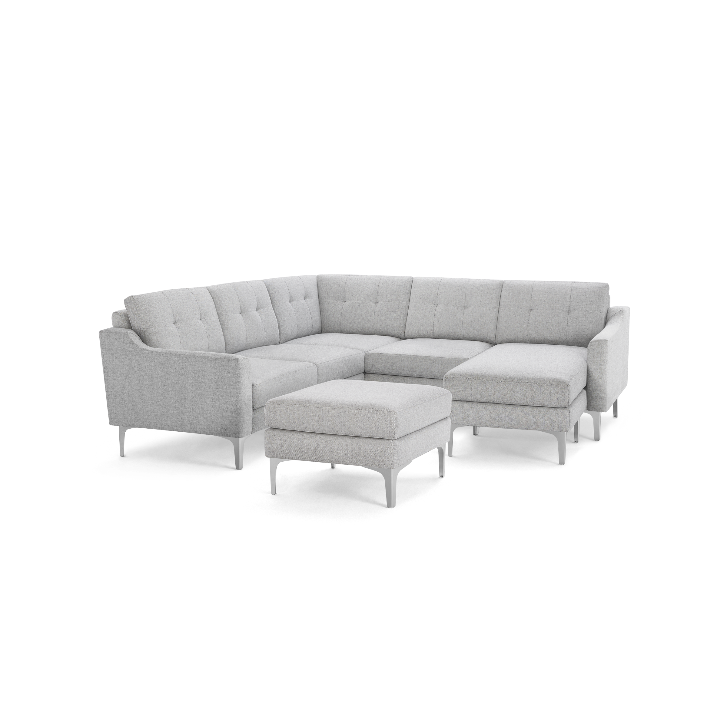 Light gray modern sectional sofa with tufted back cushions, metal legs, and matching ottoman on dark background.