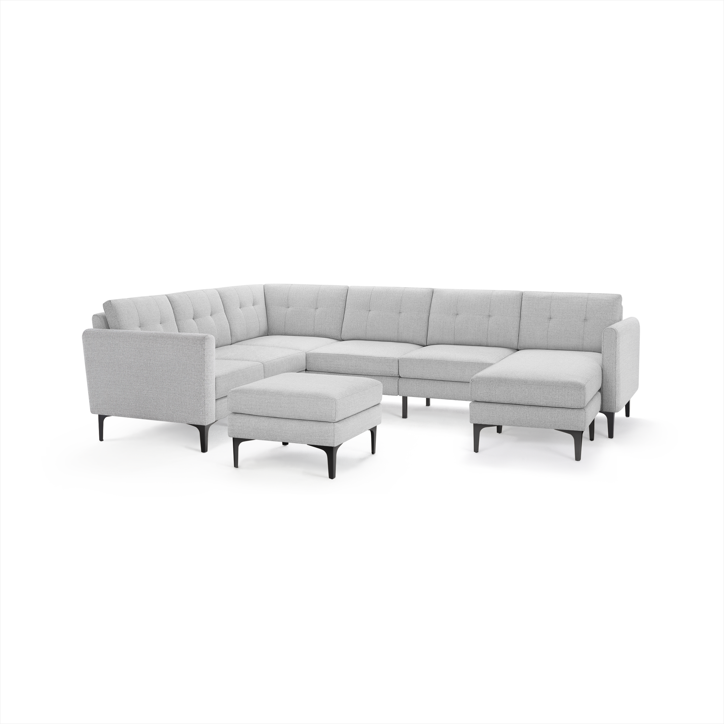 Light gray modern sectional sofa with tufted back cushions and matching ottoman, supported by sleek black legs.