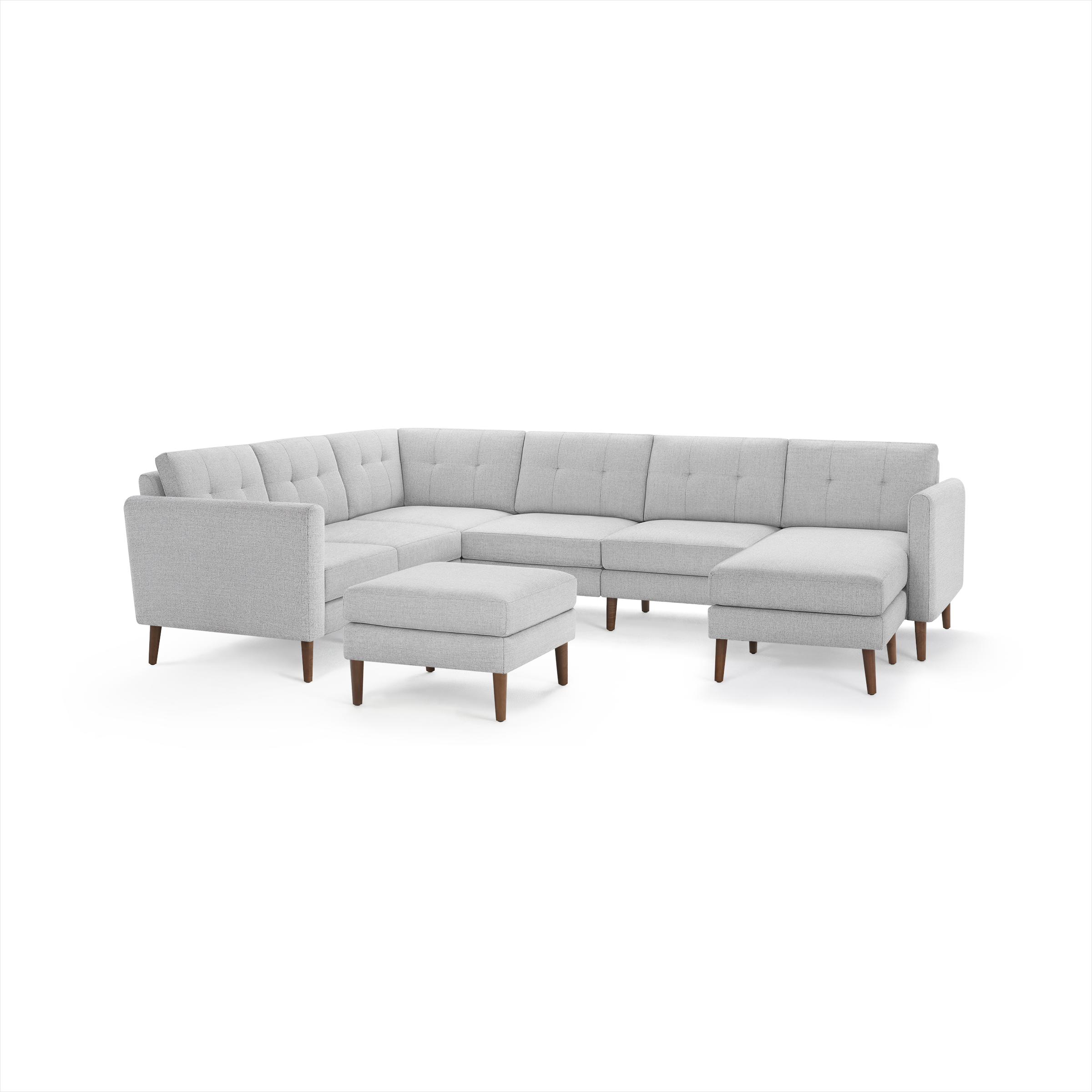 Light gray fabric sectional sofa with tufted back cushions, wooden legs, and matching ottoman, arranged in an L-shape.