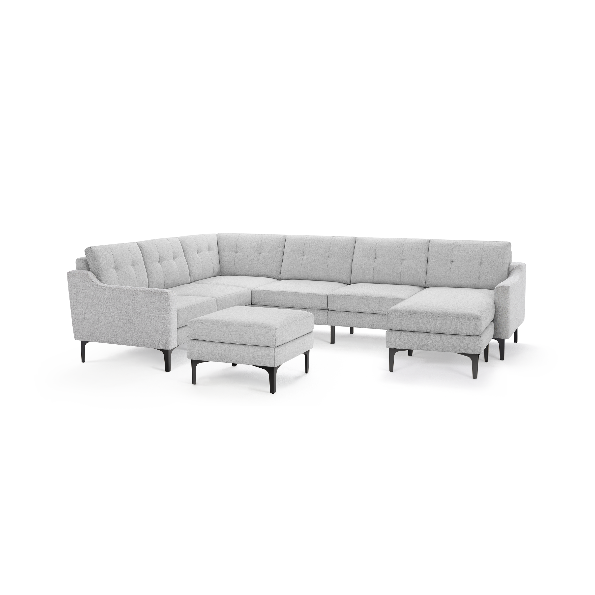 Light gray modern sectional sofa with tufted cushions, slim black legs, and a matching ottoman.