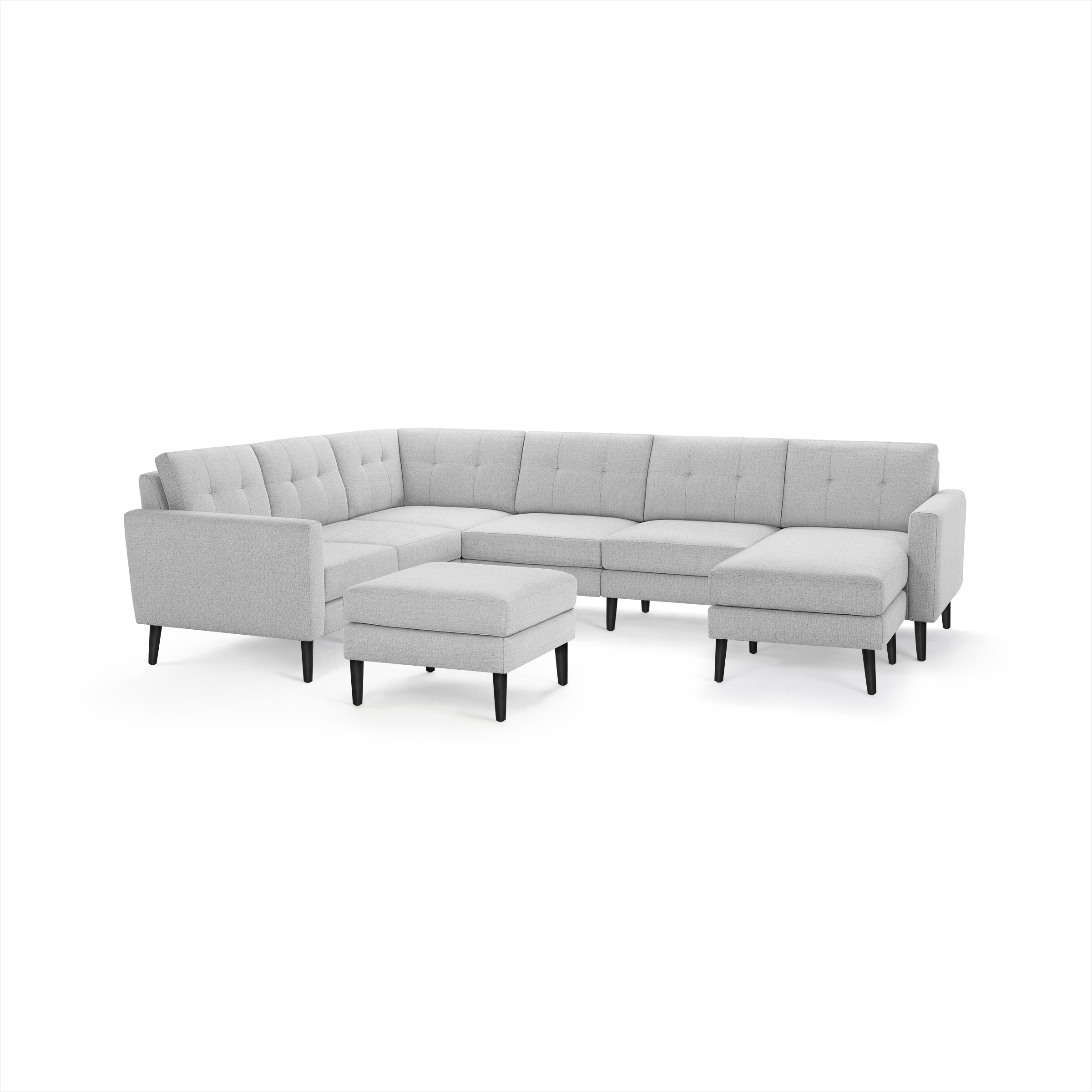 Light gray fabric sectional sofa with tufted cushions, black tapered legs, and matching ottoman, modern and spacious design.