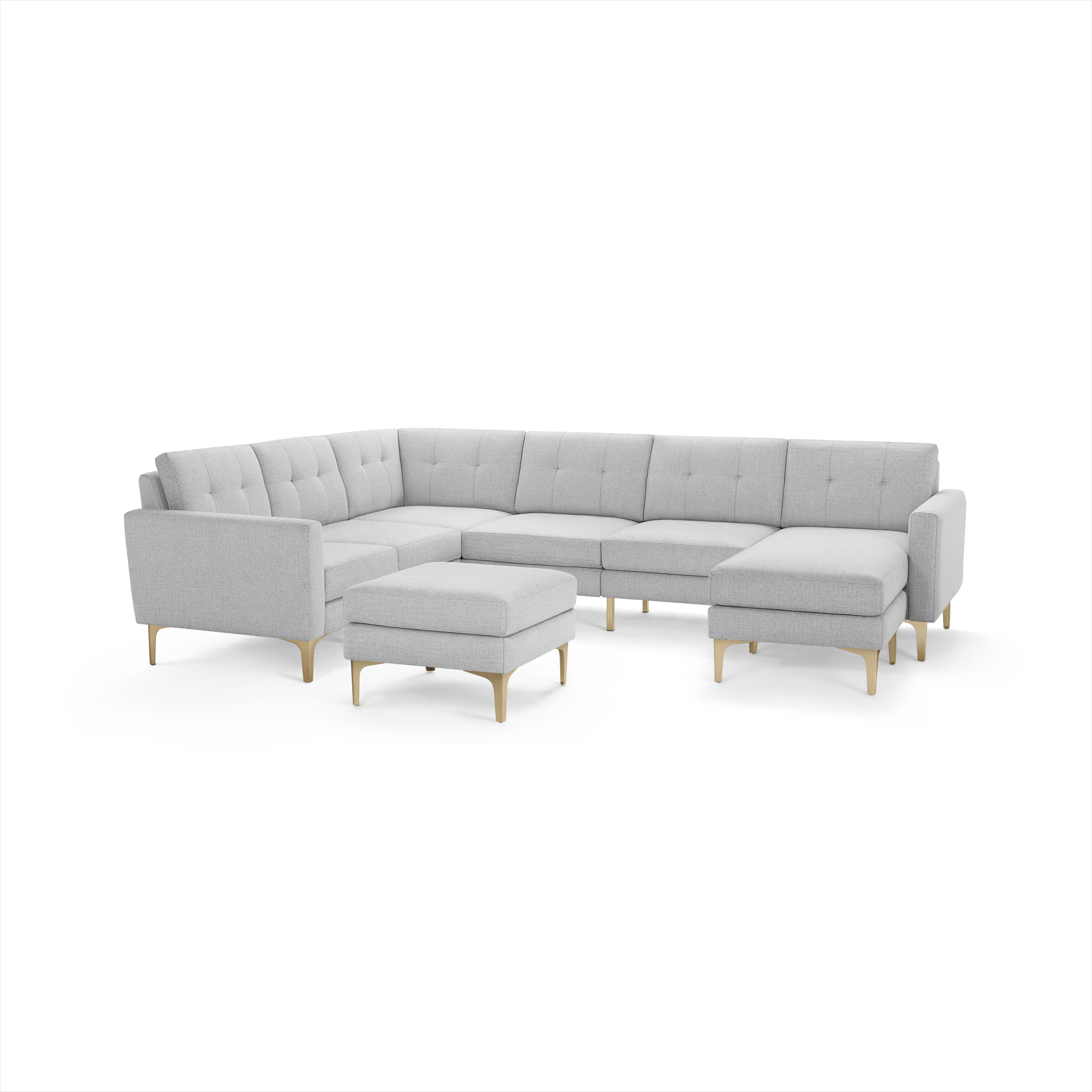 Light gray modern sectional sofa with tufted cushions, wooden legs, and matching ottoman, designed for spacious living rooms.