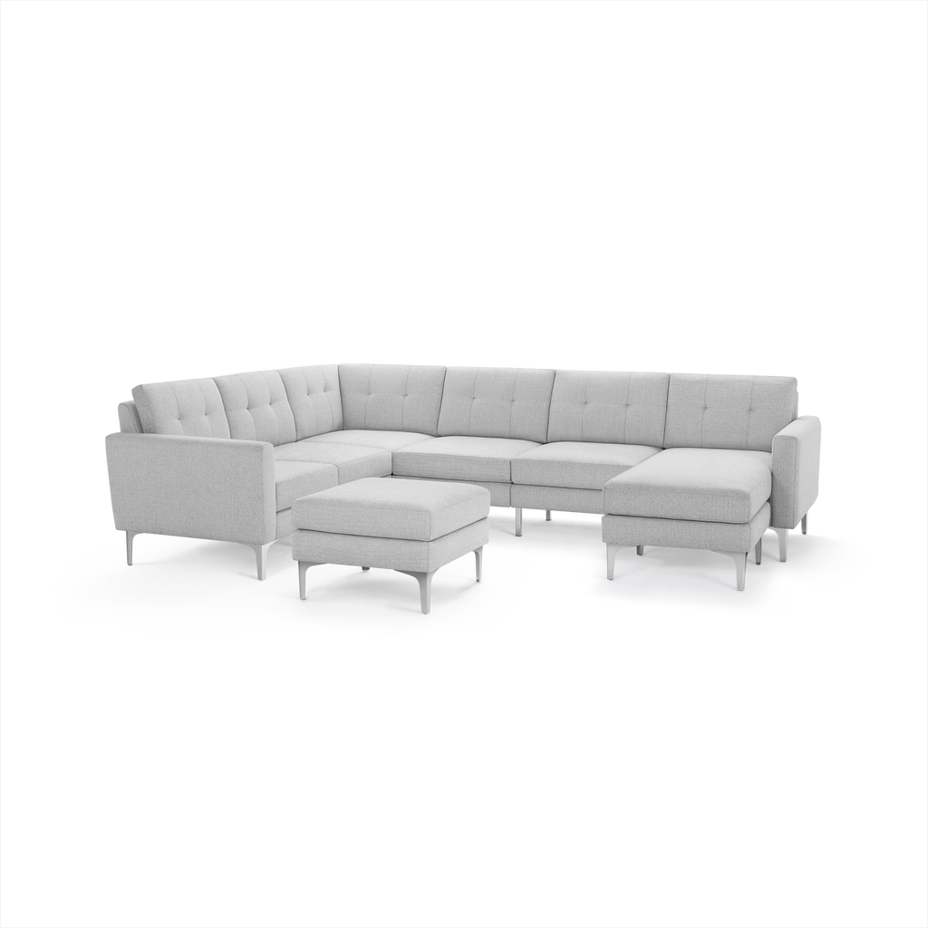 Light gray modern sectional sofa with tufted cushions, metal legs, and matching ottoman, designed for spacious living areas.