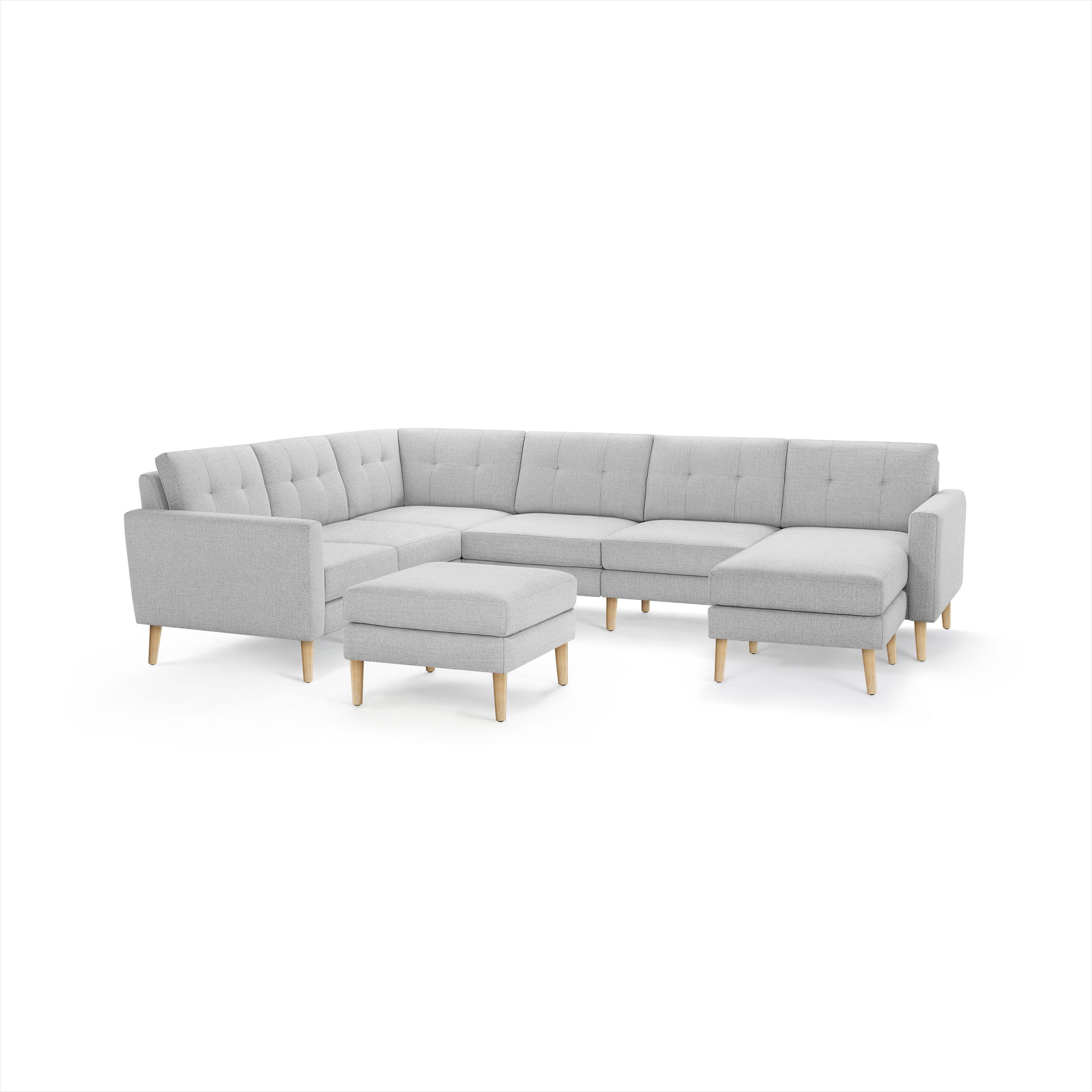 Light grey fabric L-shaped sectional sofa with tufted backrest, wooden angled legs, and matching ottoman.