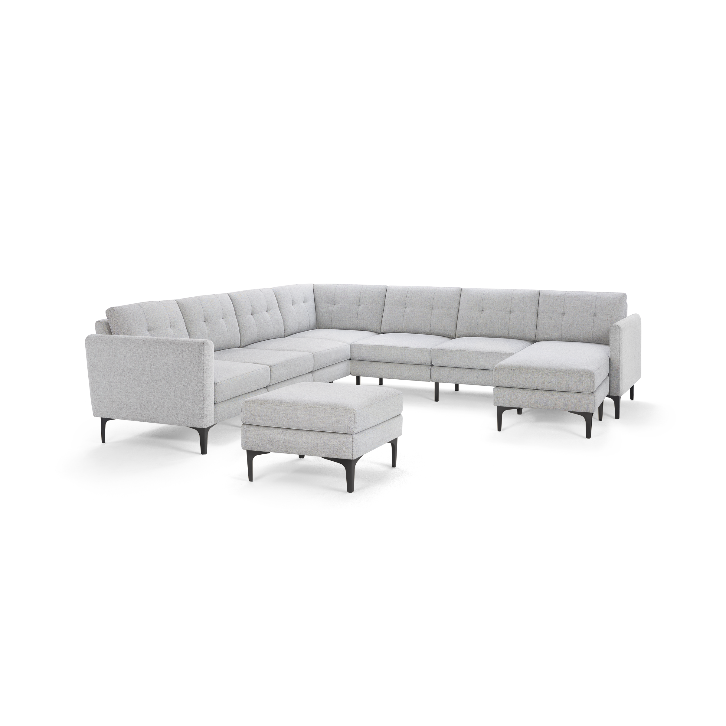 Light gray modern L-shaped sectional sofa with tufted cushions and matching ottoman on black legs, isolated on white background.