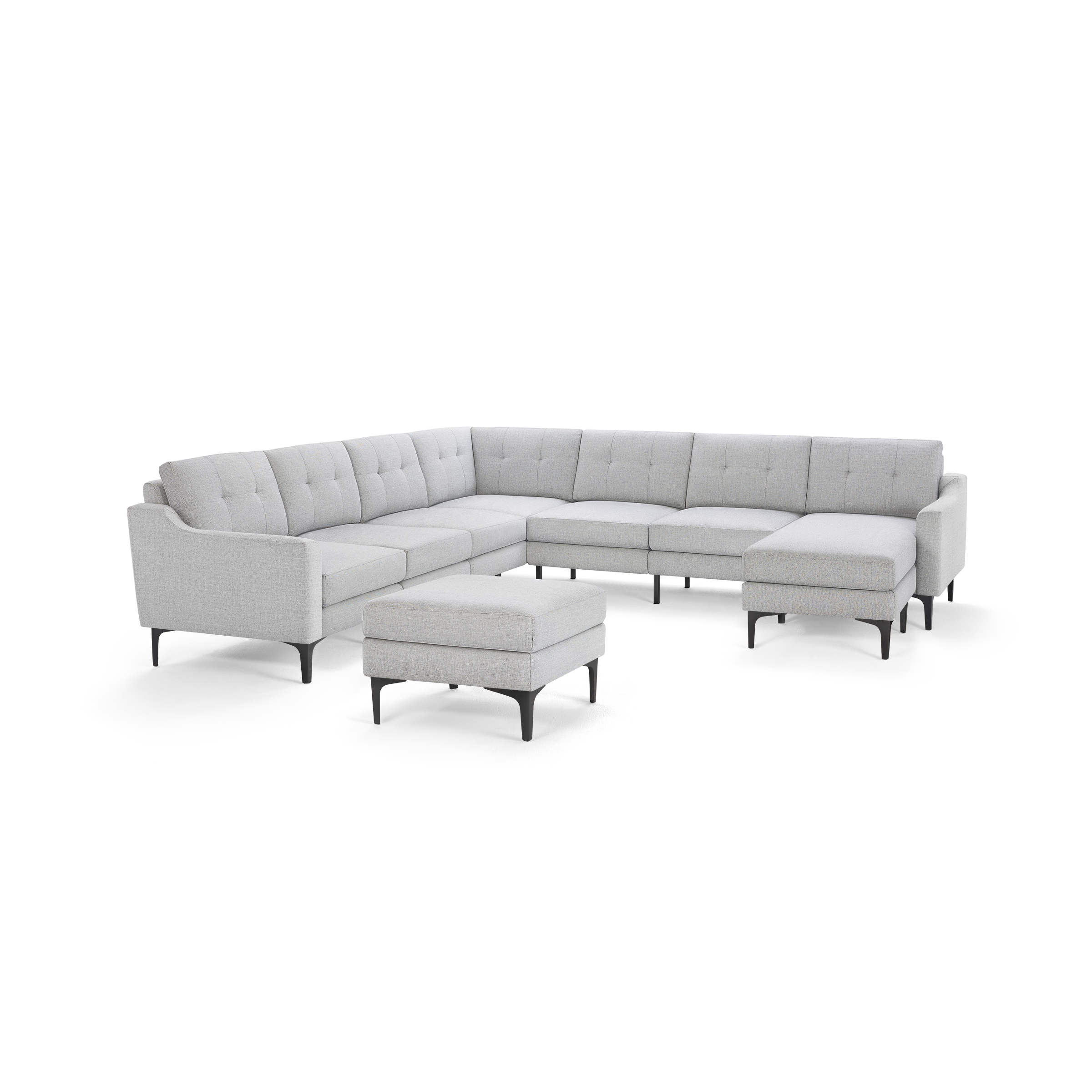 Light gray modern sectional sofa with tufted back cushions, black tapered legs, and matching ottoman.