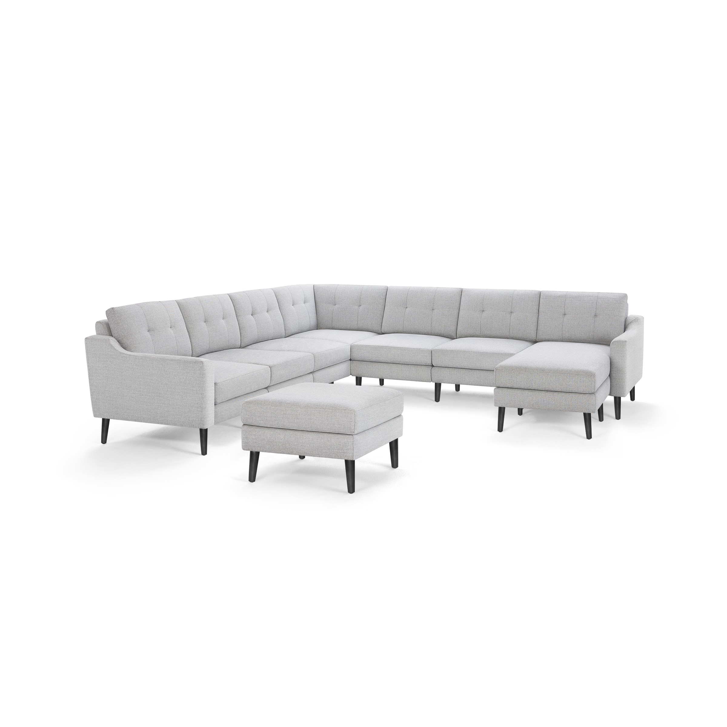 Light gray fabric sectional sofa with tufted cushions, black tapered legs, and matching ottoman on white background.