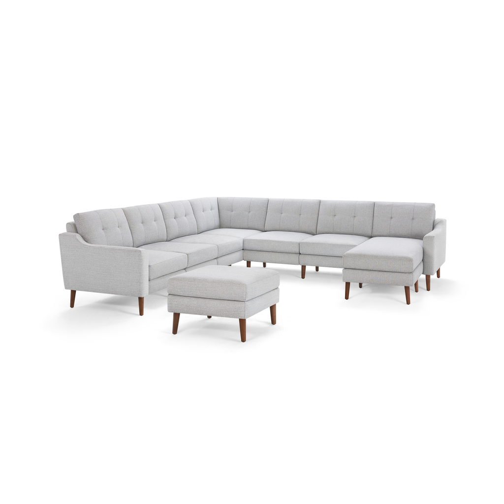 Light gray fabric sectional sofa with tufted back cushions, wooden legs, and matching ottoman, designed in modern style.