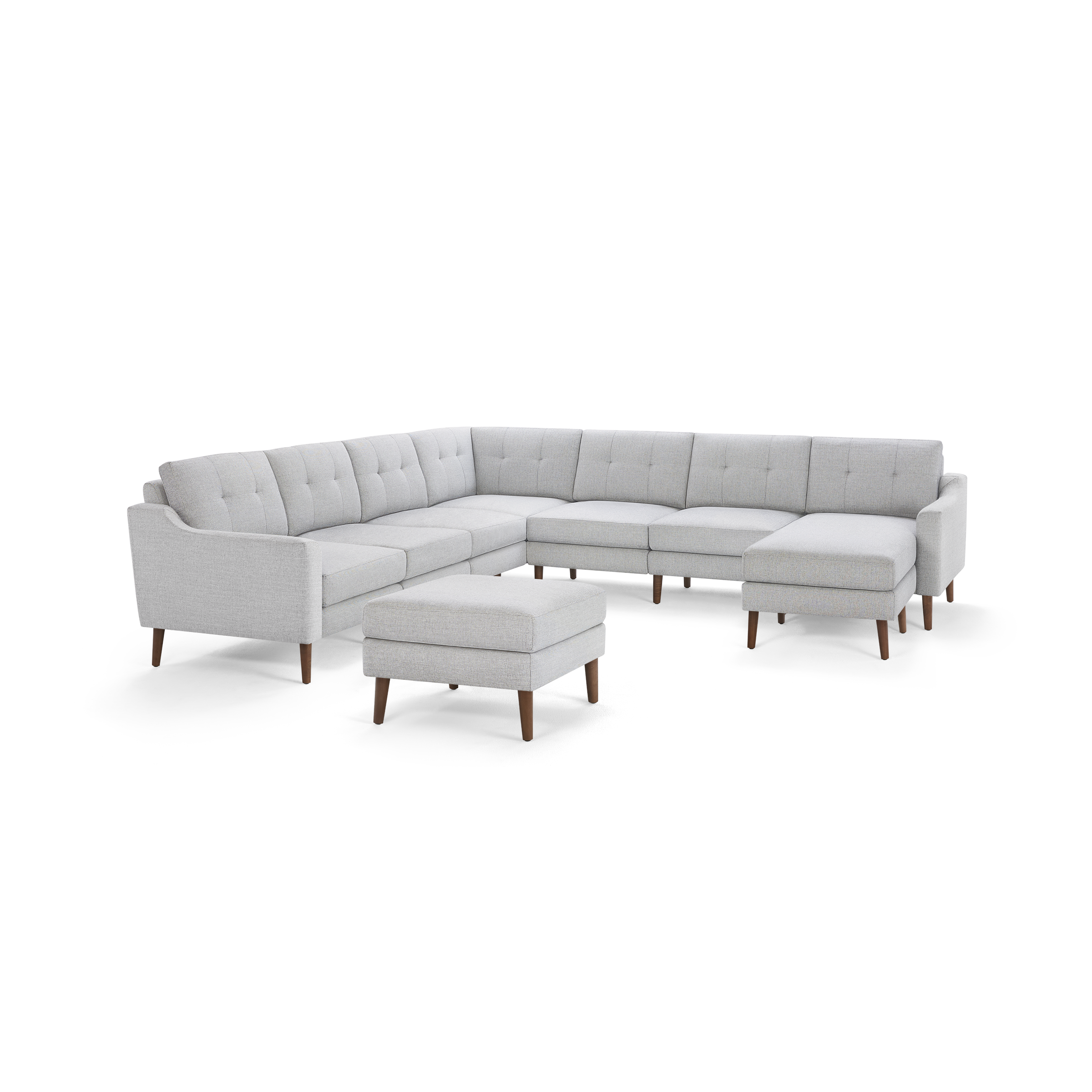 Light gray fabric sectional sofa with tufted back cushions, wooden legs, and matching ottoman, designed in modern style.