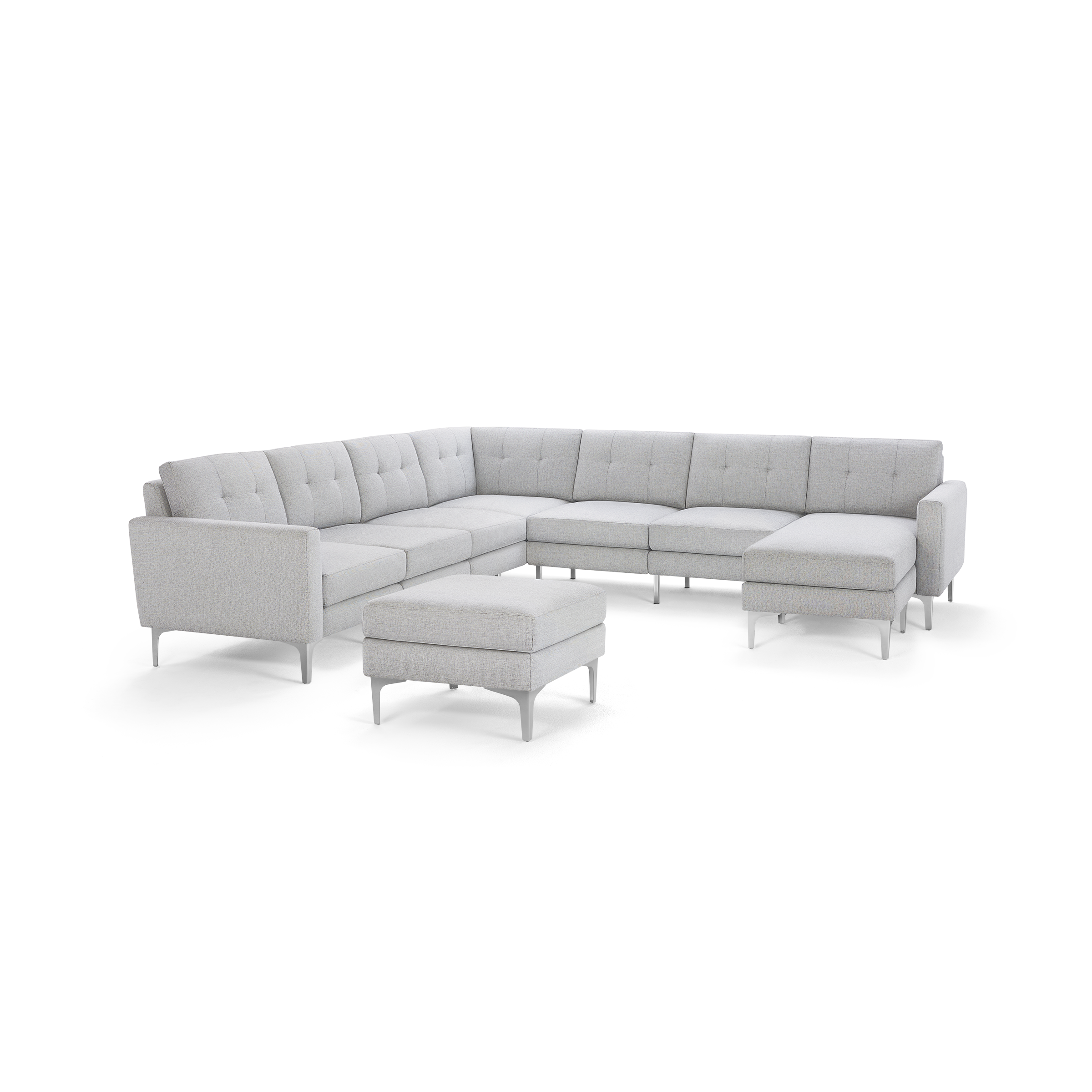 Light gray fabric L-shaped sectional sofa with tufted cushions and matching ottoman, supported by slim metal legs.