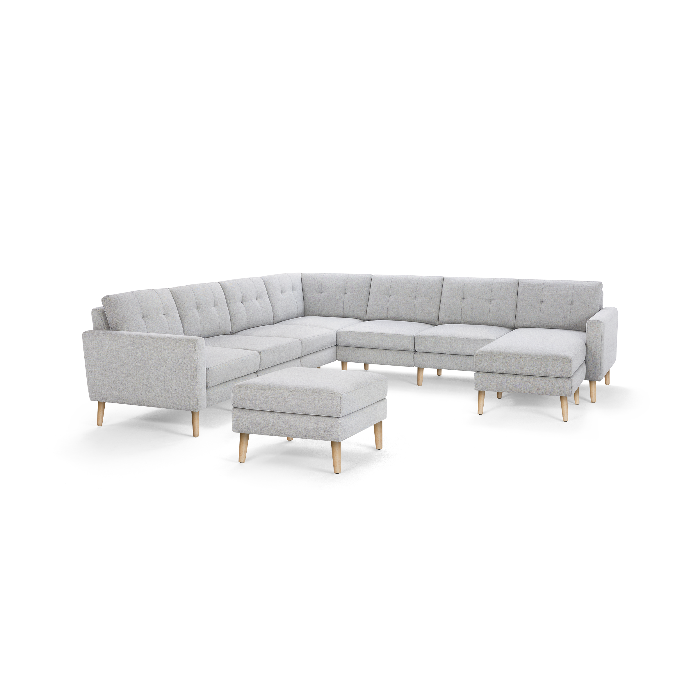 Light gray upholstered L-shaped sectional sofa with tufted back cushions and wooden legs, including a matching square ottoman.
