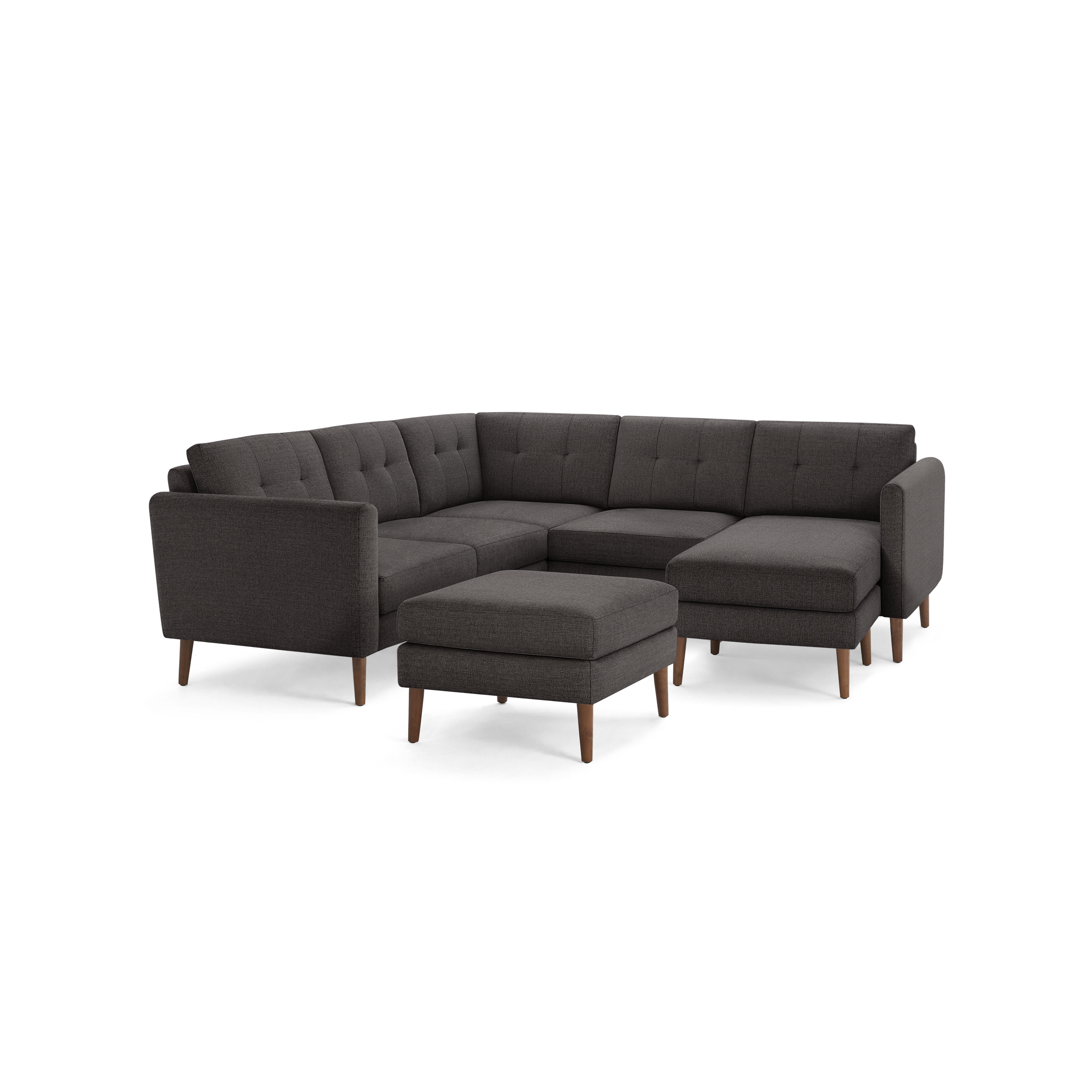 Dark gray fabric sectional sofa with tufted cushions, wooden legs, and a matching ottoman, featuring an L-shaped design.