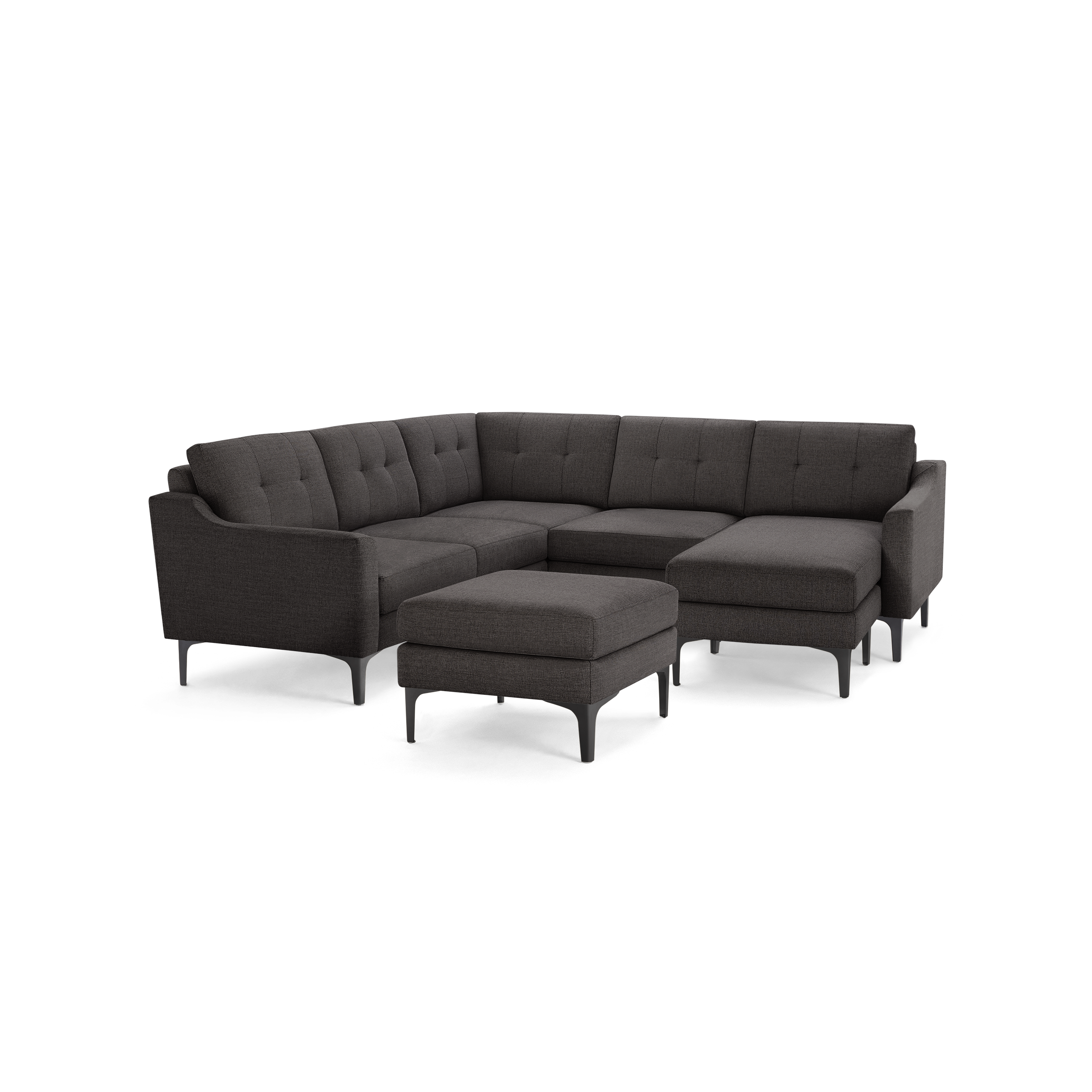 Dark gray fabric sectional sofa with tufted back cushions, angled armrests, chaise lounge, and matching ottoman on black legs.