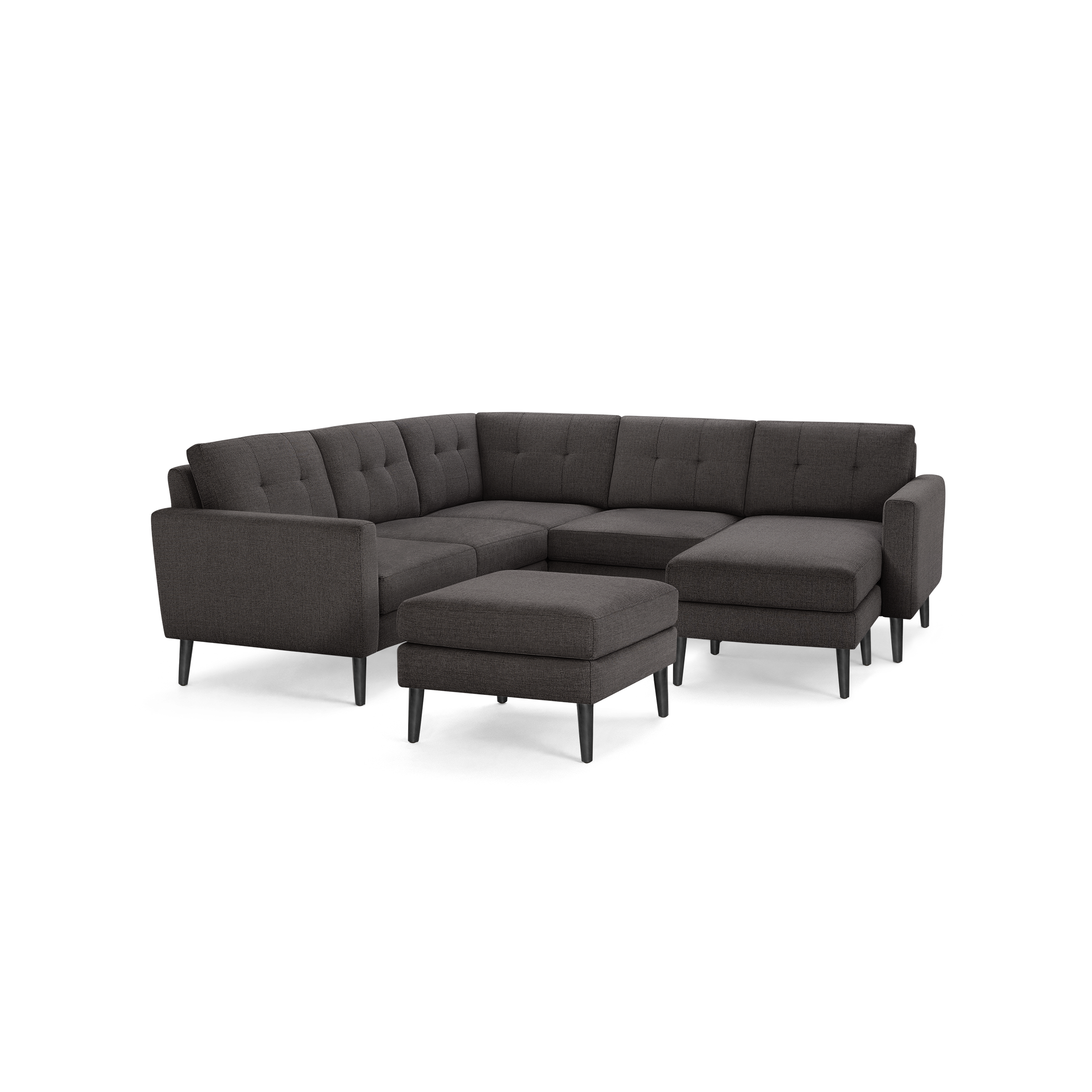 Dark gray tufted fabric sectional sofa with matching ottoman, featuring clean lines and mid-century modern black legs.
