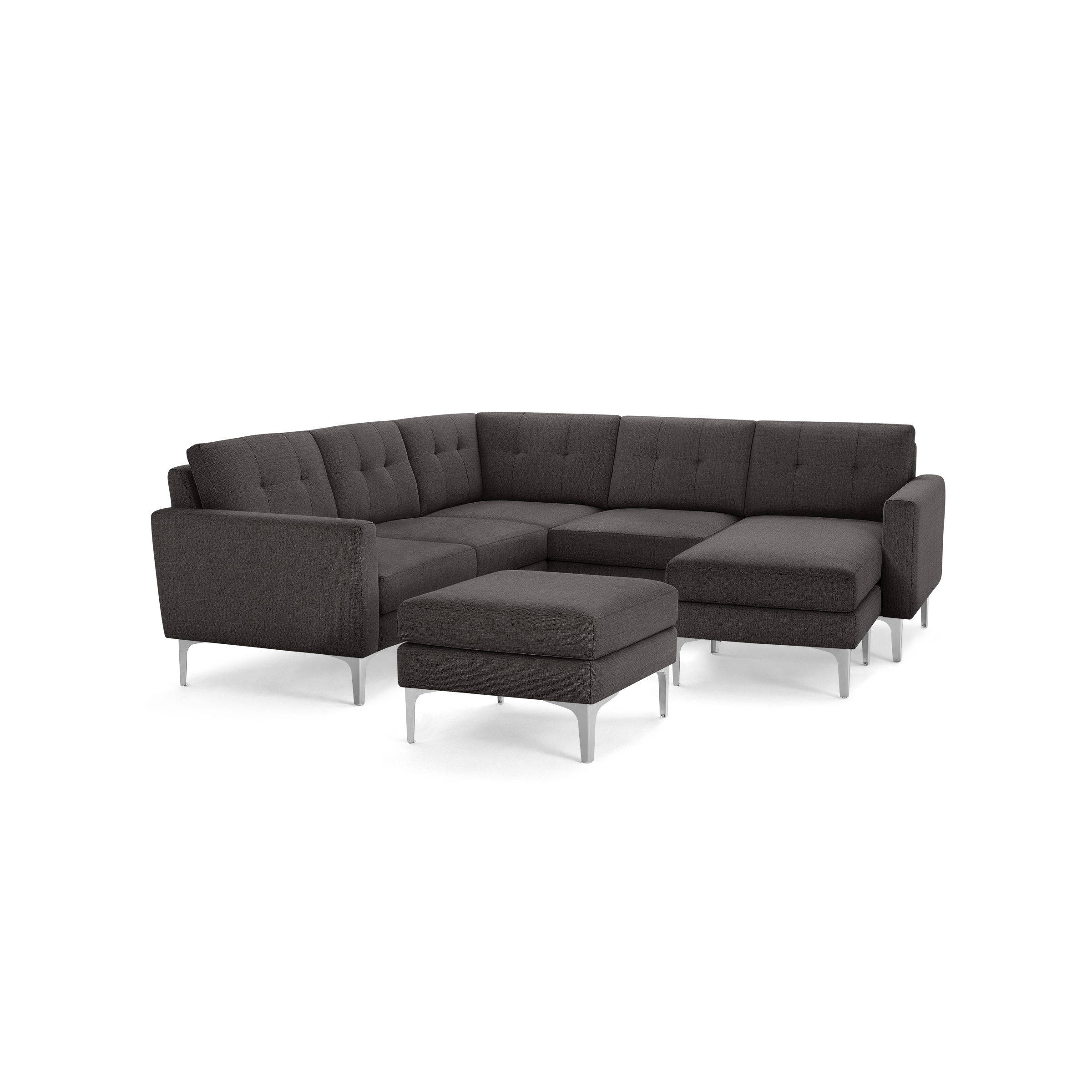 Dark gray modern sectional sofa with tufted cushions, metal legs, and a matching ottoman, shown on a black background.