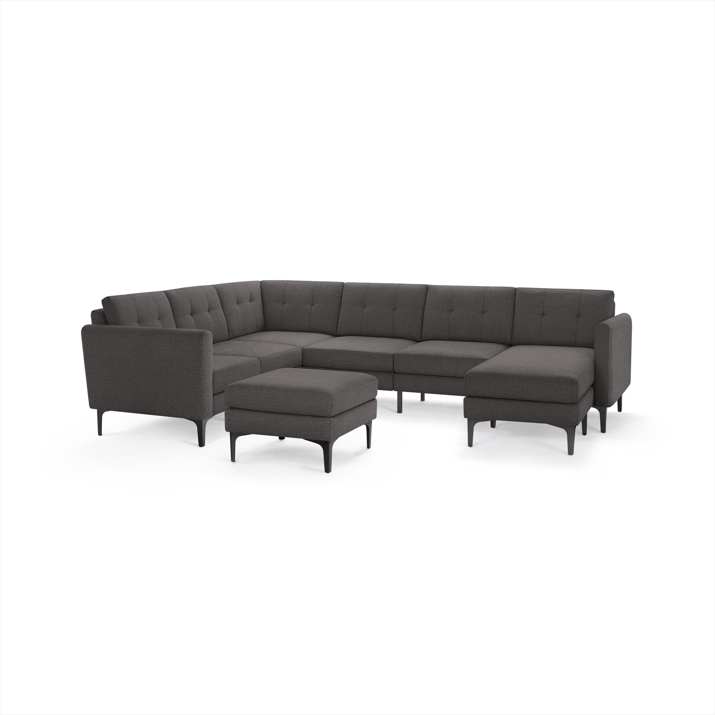 Dark gray fabric upholstered modern modular sectional sofa with tufted back cushions and matching ottoman, supported by slender black legs.