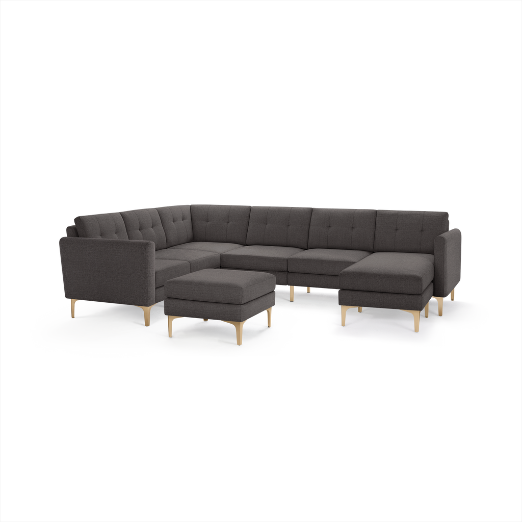 Modern dark gray L-shaped sectional sofa with button-tufted cushions, wooden legs, and matching ottoman.