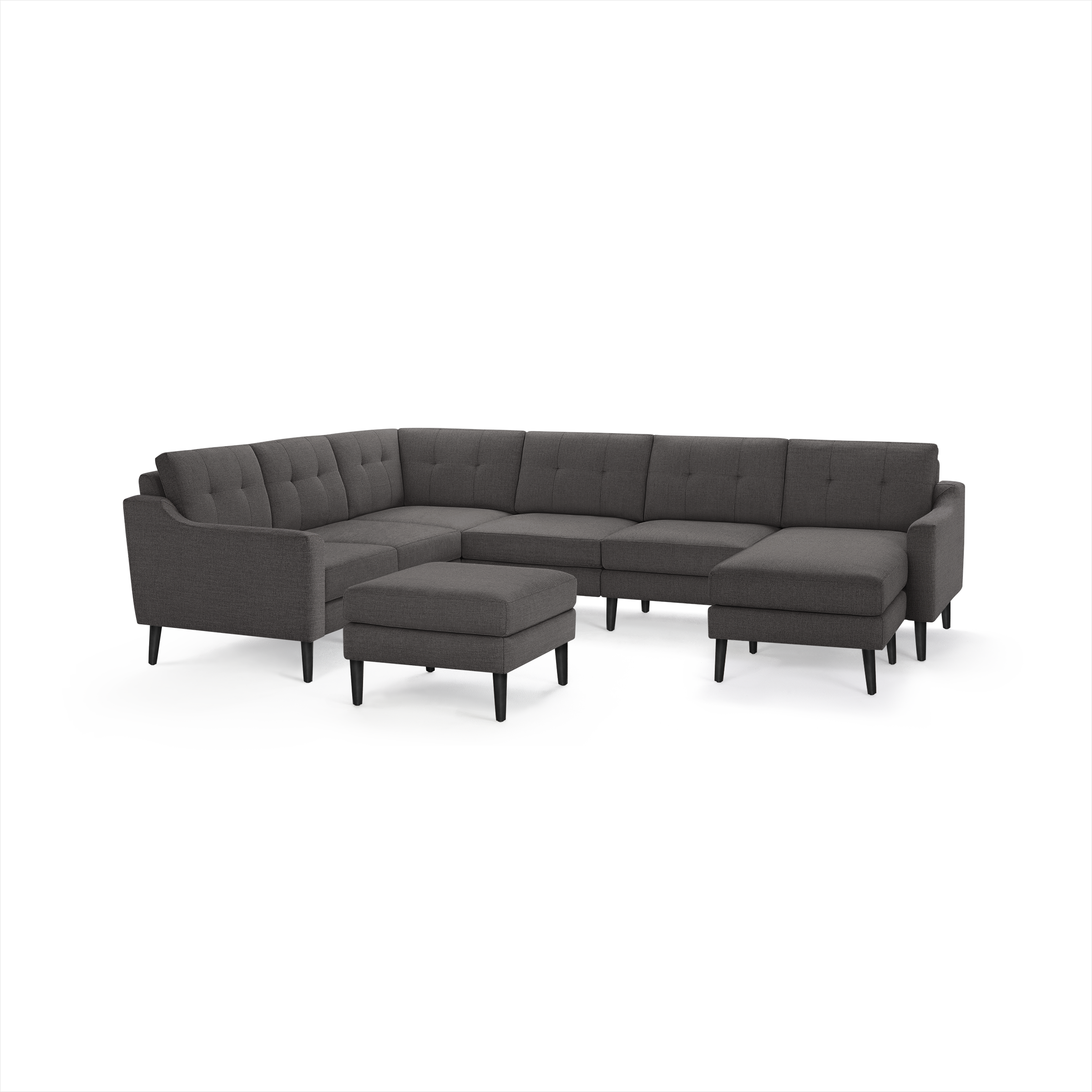 Dark gray modern sectional sofa with tufted back cushions and matching ottoman, featuring angled armrests and black wooden legs.