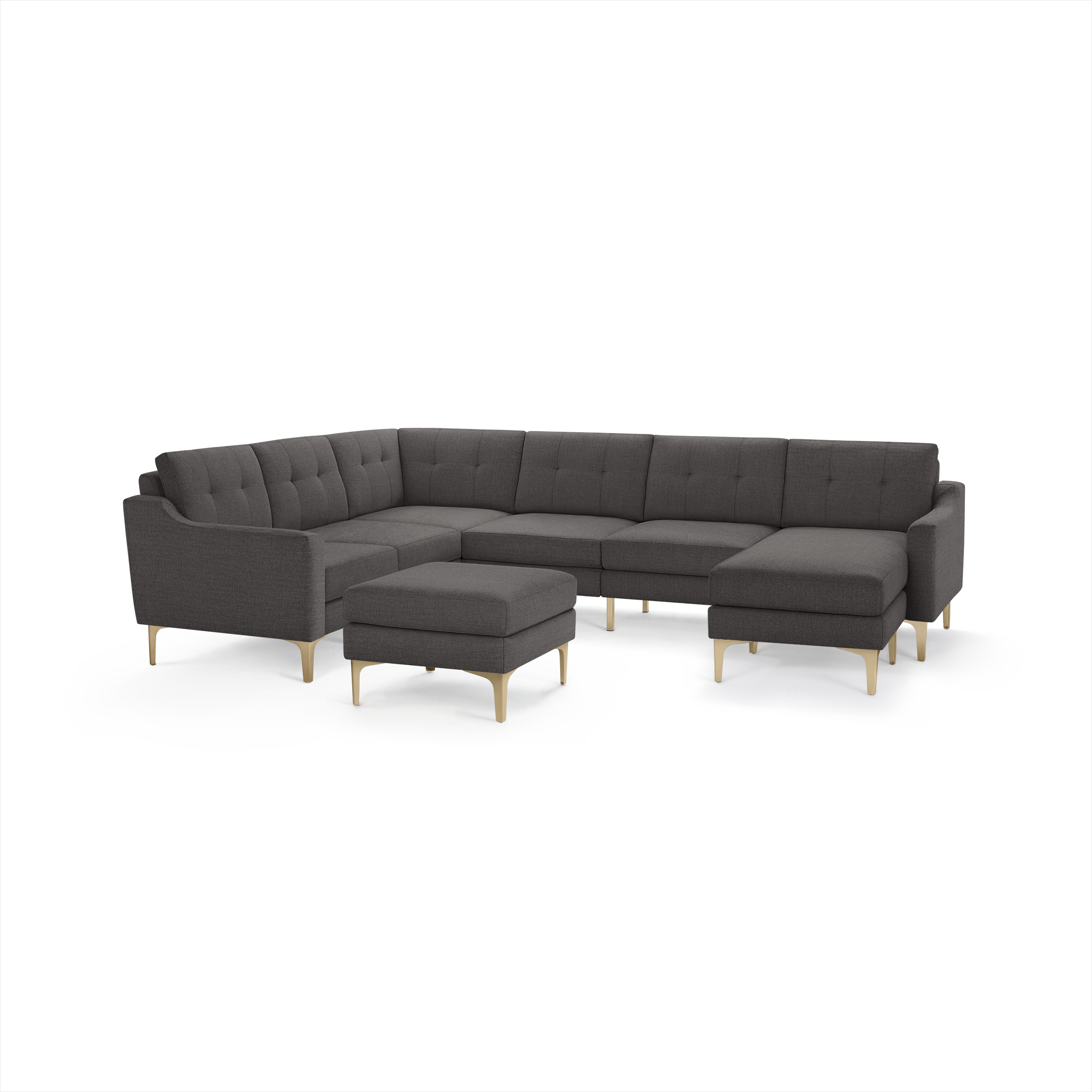 Dark gray L-shaped sectional sofa with tufted cushions, wooden legs, and matching ottoman isolated on white background.