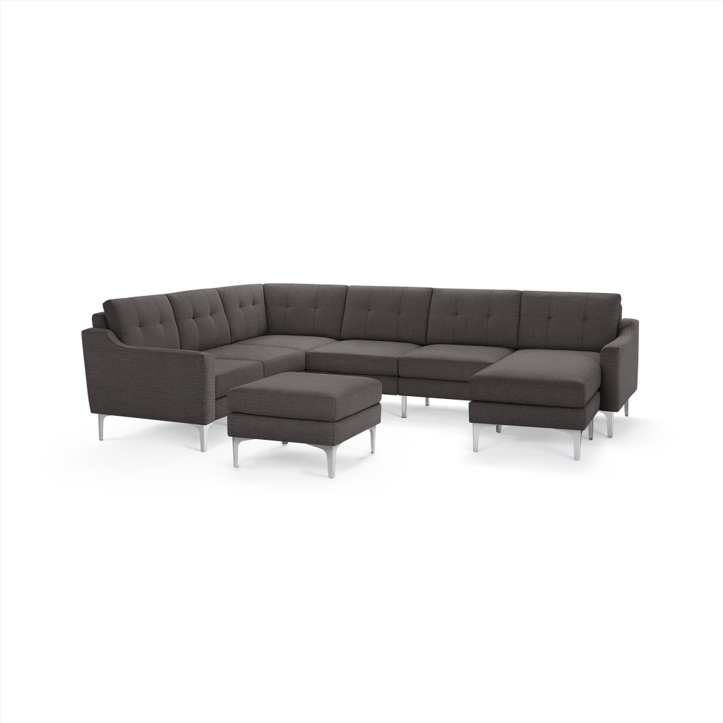 Dark gray fabric sectional sofa with tufted back cushions, metal legs, and a matching ottoman in front on white background.