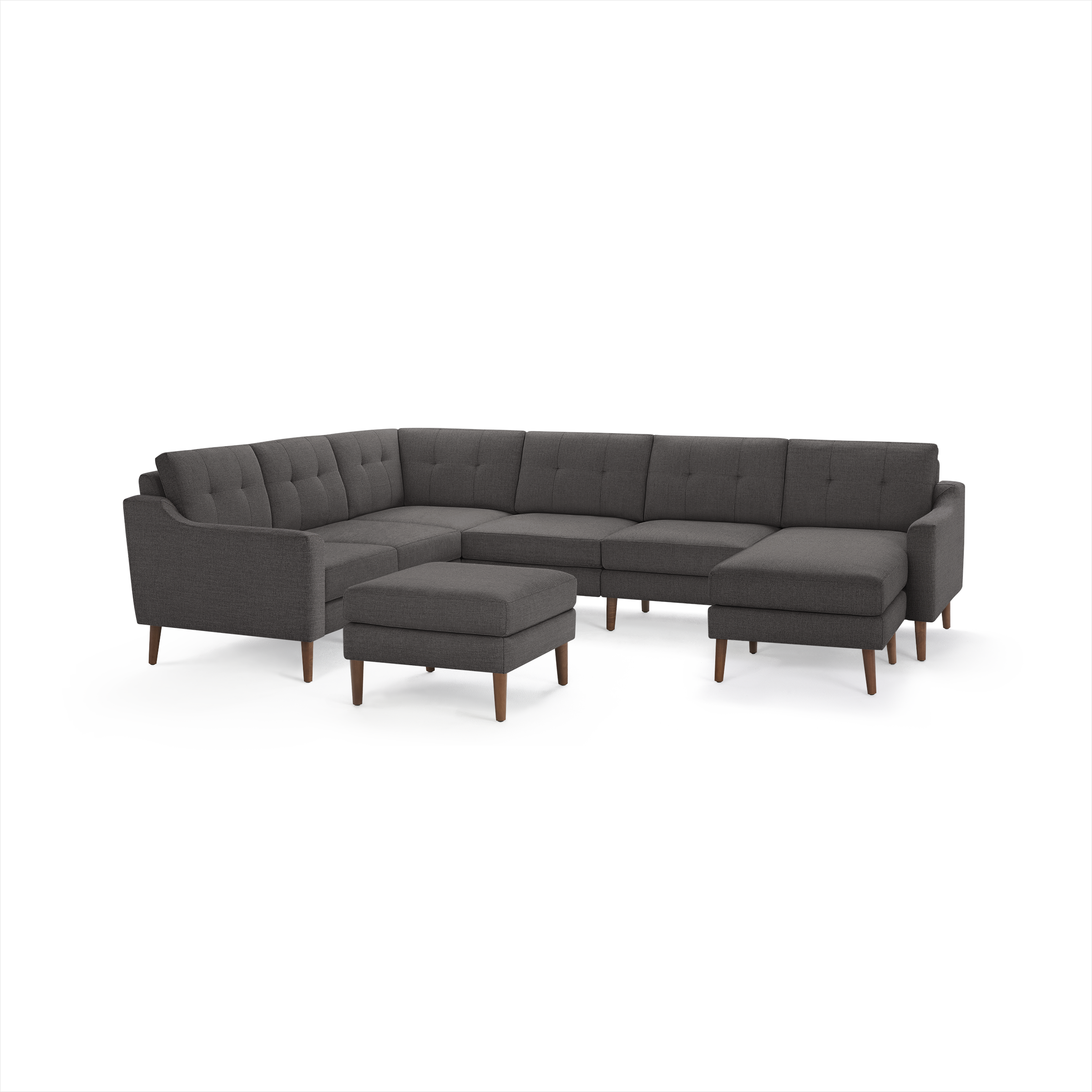 Large dark gray fabric sectional sofa with button-tufted cushions, wooden legs, and matching ottoman.