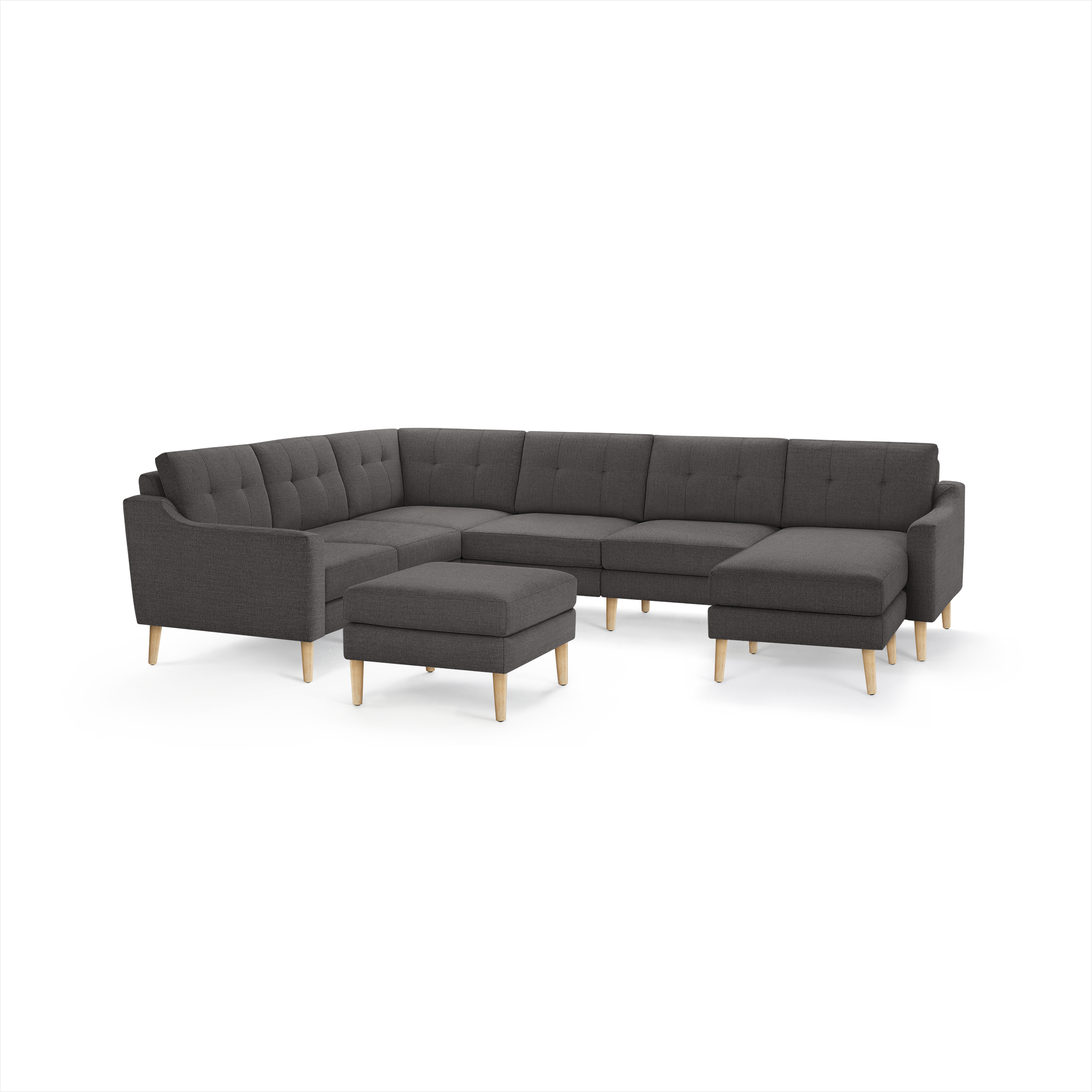 Dark gray fabric sectional sofa with tufted back cushions, wooden legs, and a matching ottoman, designed for modern living rooms.