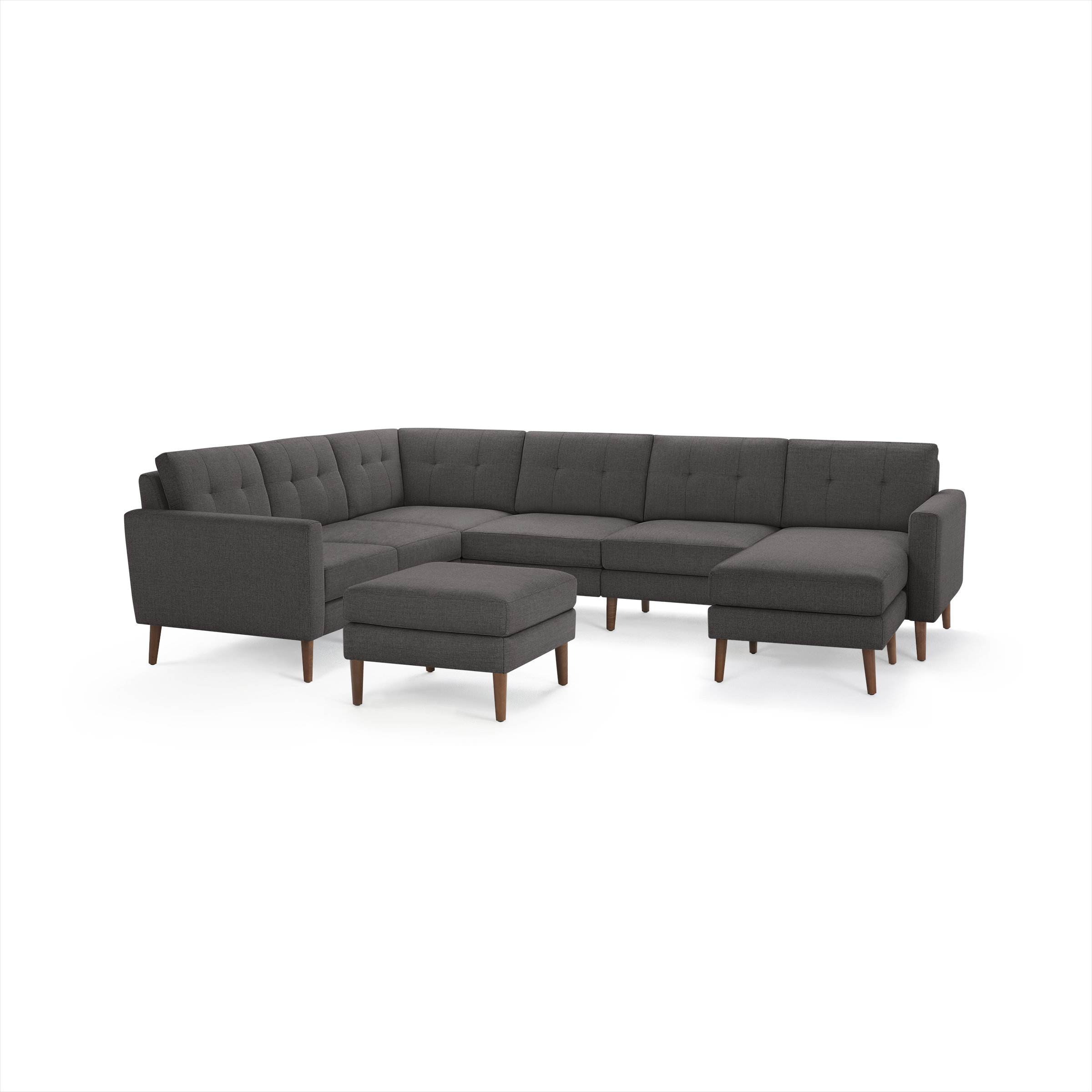 Dark gray upholstered L-shaped sectional sofa with tufted back cushions and wooden legs, accompanied by a matching ottoman.