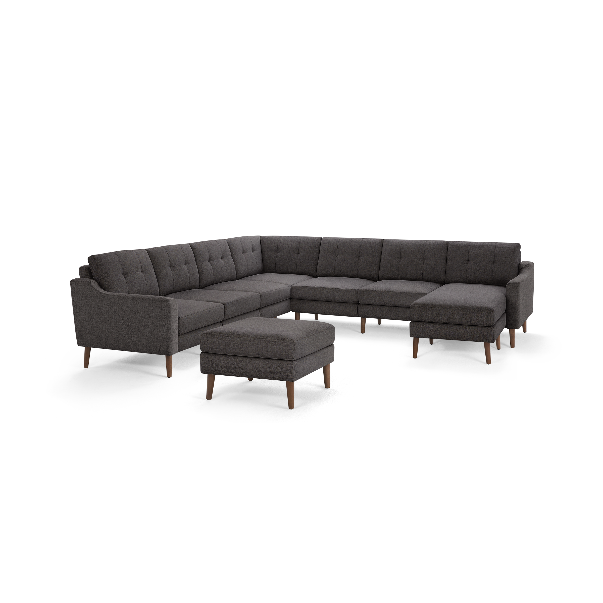 Dark gray tufted fabric sectional sofa with wooden legs and matching ottoman, modern and spacious L-shaped design.