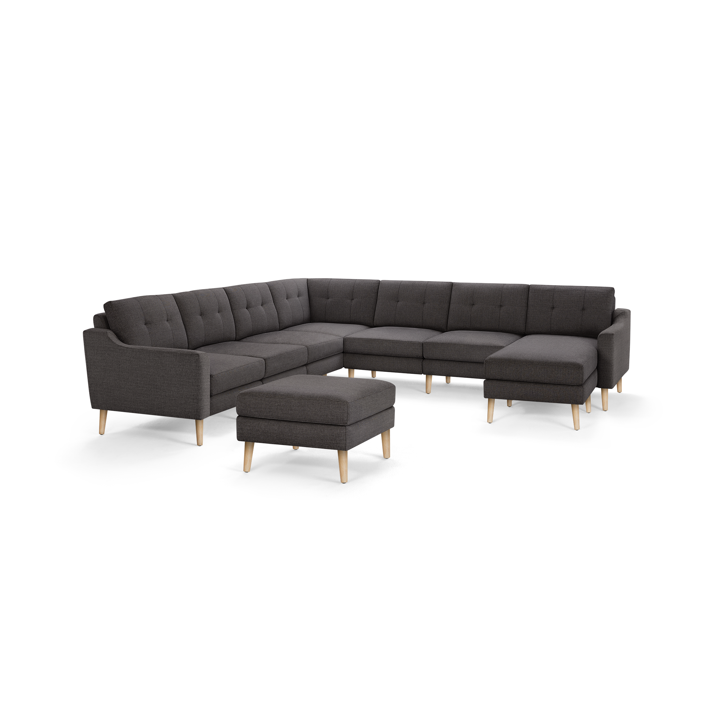 Dark gray L-shaped sectional sofa with button-tufted back cushions and light wooden legs, accompanied by a matching ottoman.