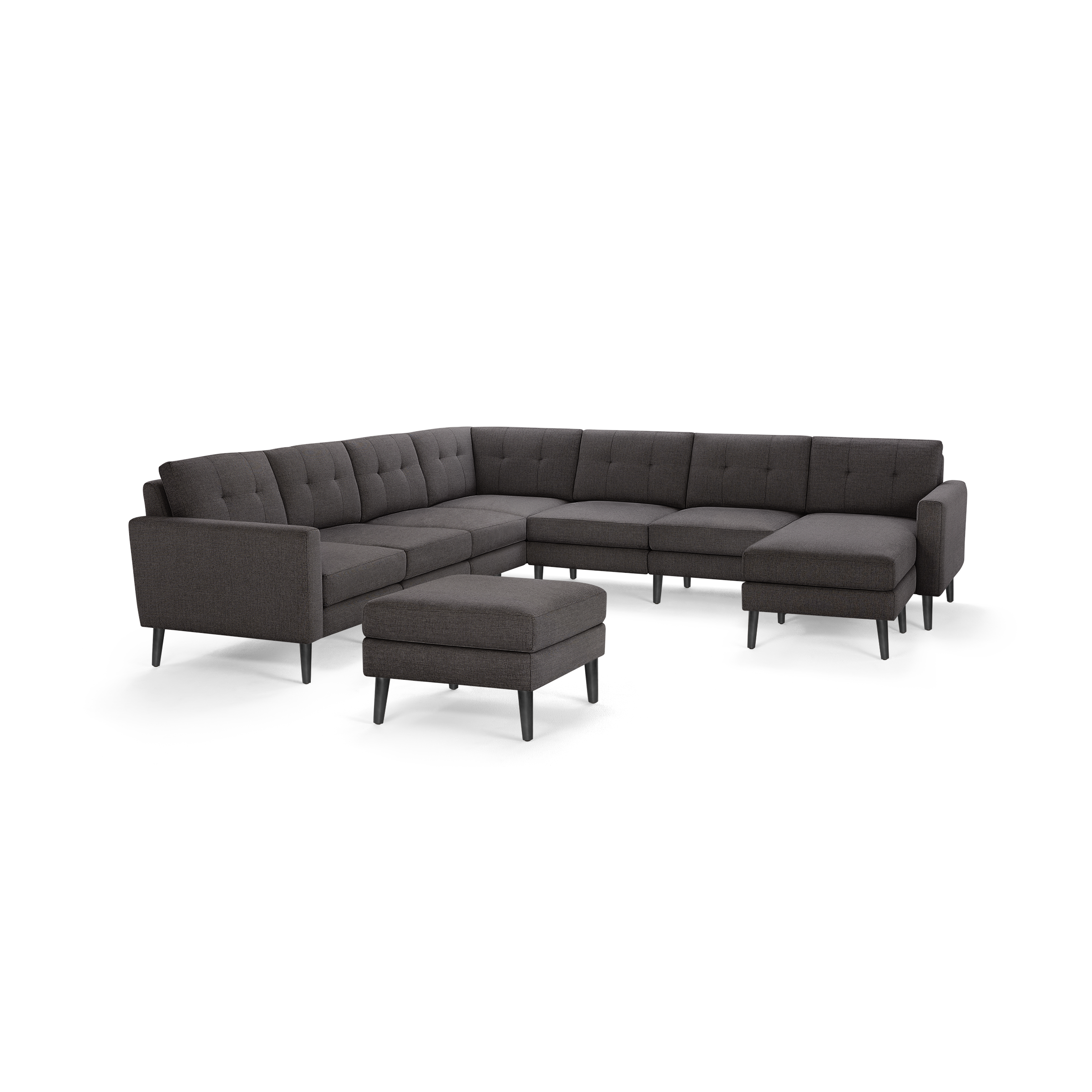 Dark gray fabric upholstered modern sectional sofa with tufted cushions and matching ottoman on black tapered legs.