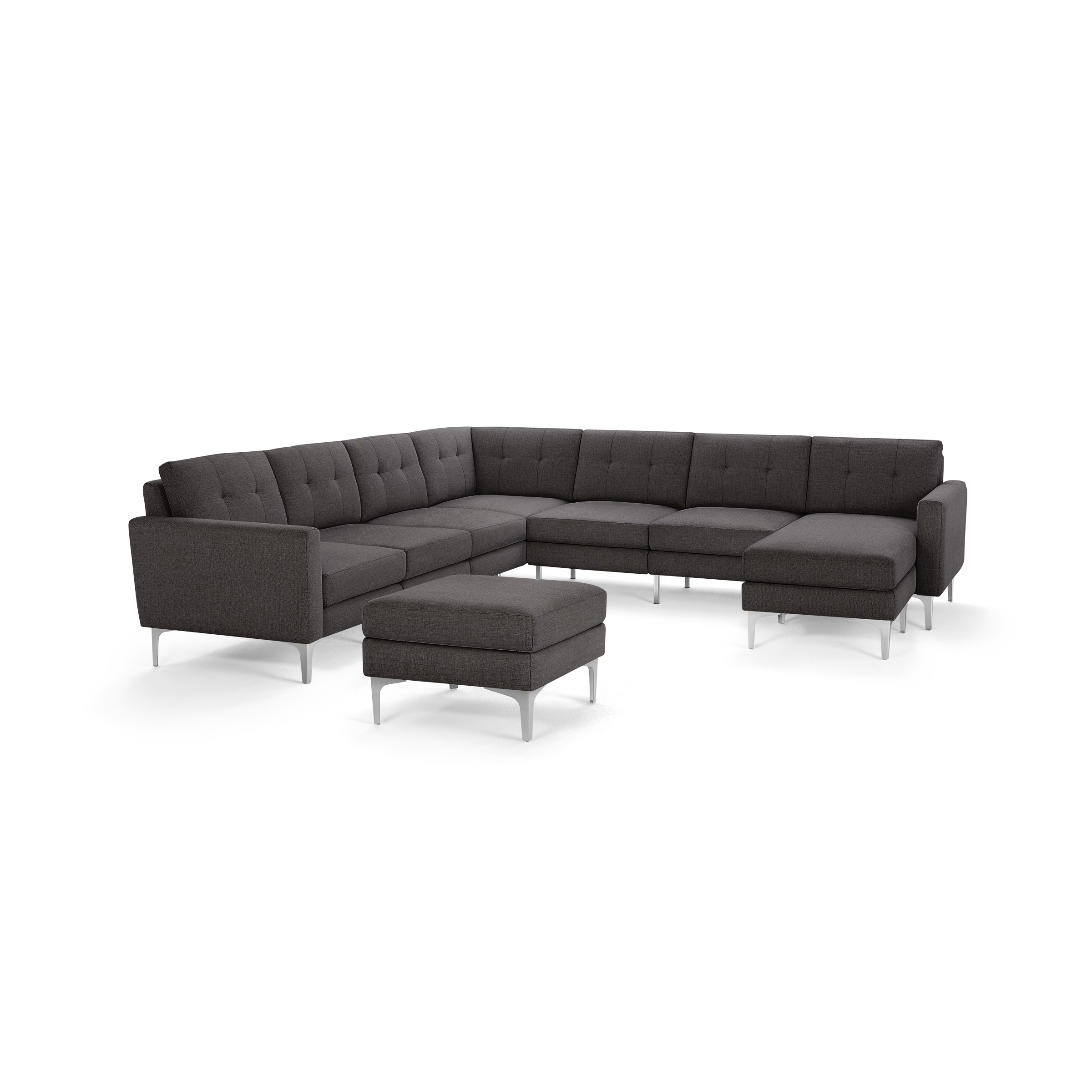 Dark gray L-shaped sectional sofa with modern metal legs and an extra matching ottoman, featuring tufted cushions and clean lines.