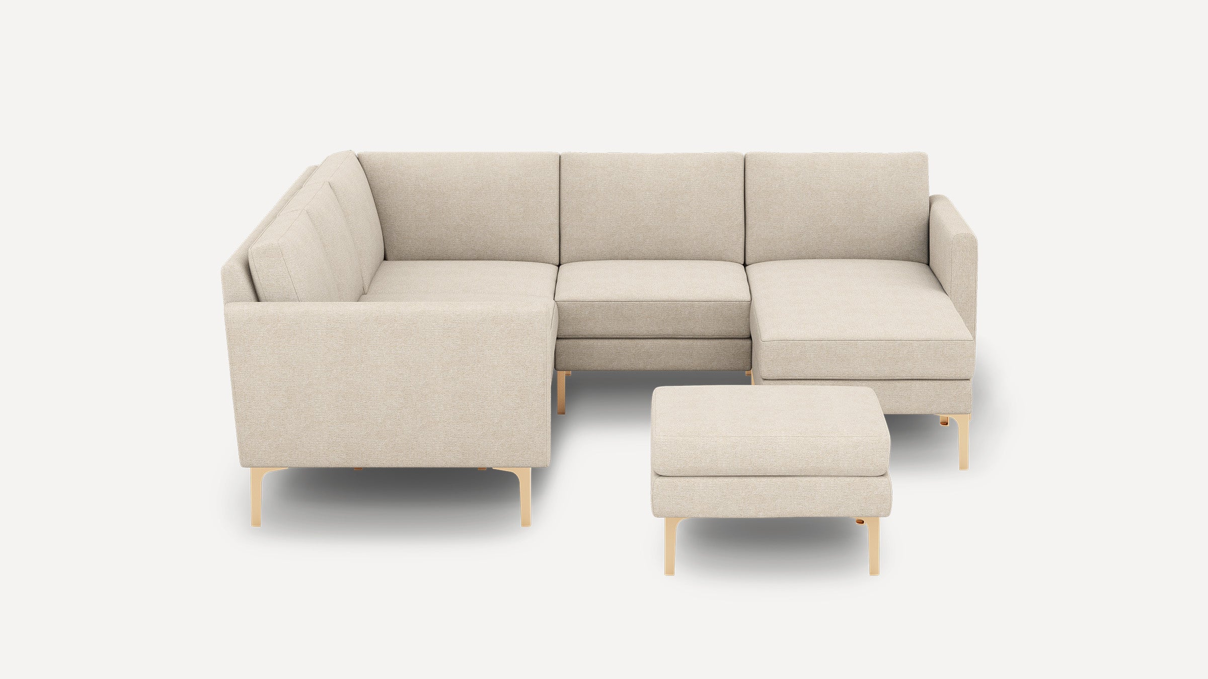 Beige upholstered L-shaped sectional sofa with clean lines, low back cushions, and matching ottoman on light wooden legs.