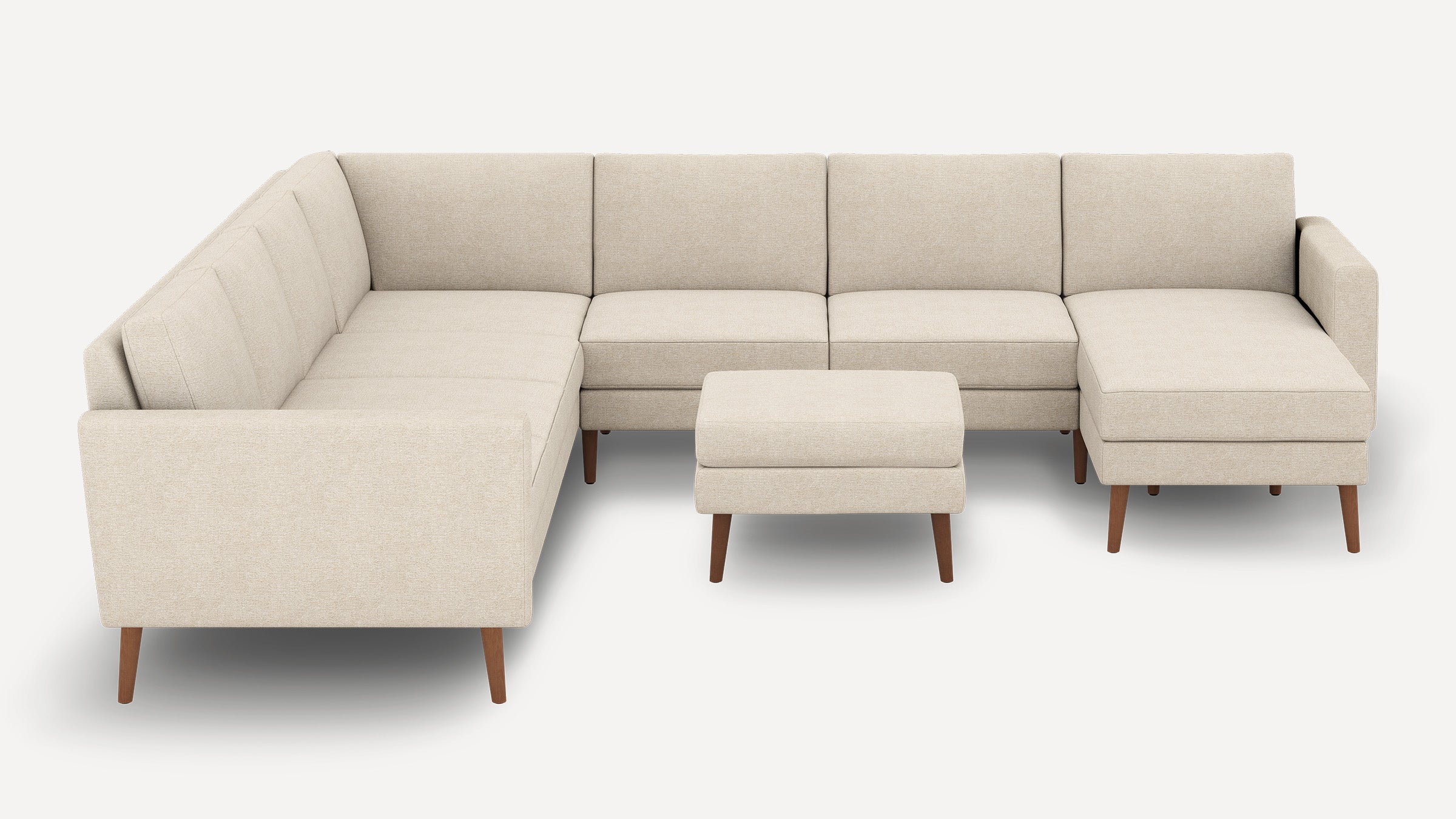 Beige L-shaped sectional sofa with clean lines, tufted cushions, wooden legs, and matching square ottoman on a white background.