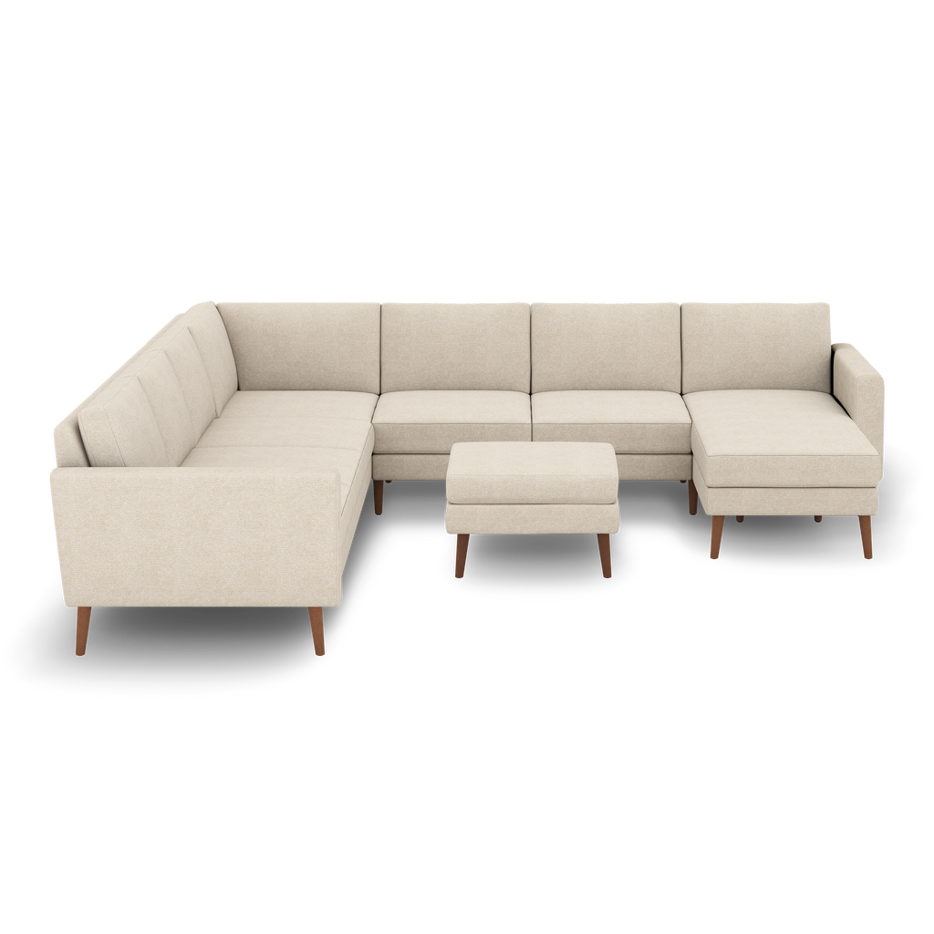Beige fabric sectional sofa with wooden legs and matching ottoman, featuring clean lines and modern design.