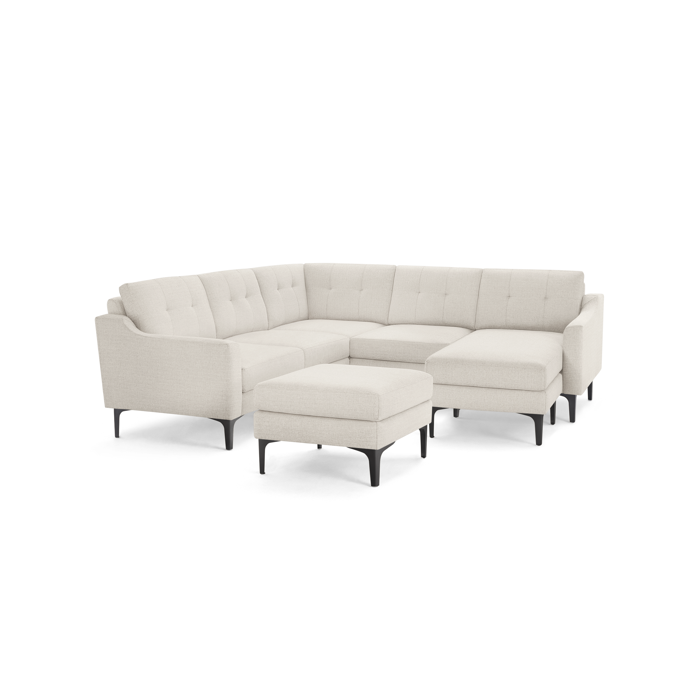 Modern beige L-shaped sectional sofa with tufted back cushions, slim black legs, and a matching ottoman on a black background.