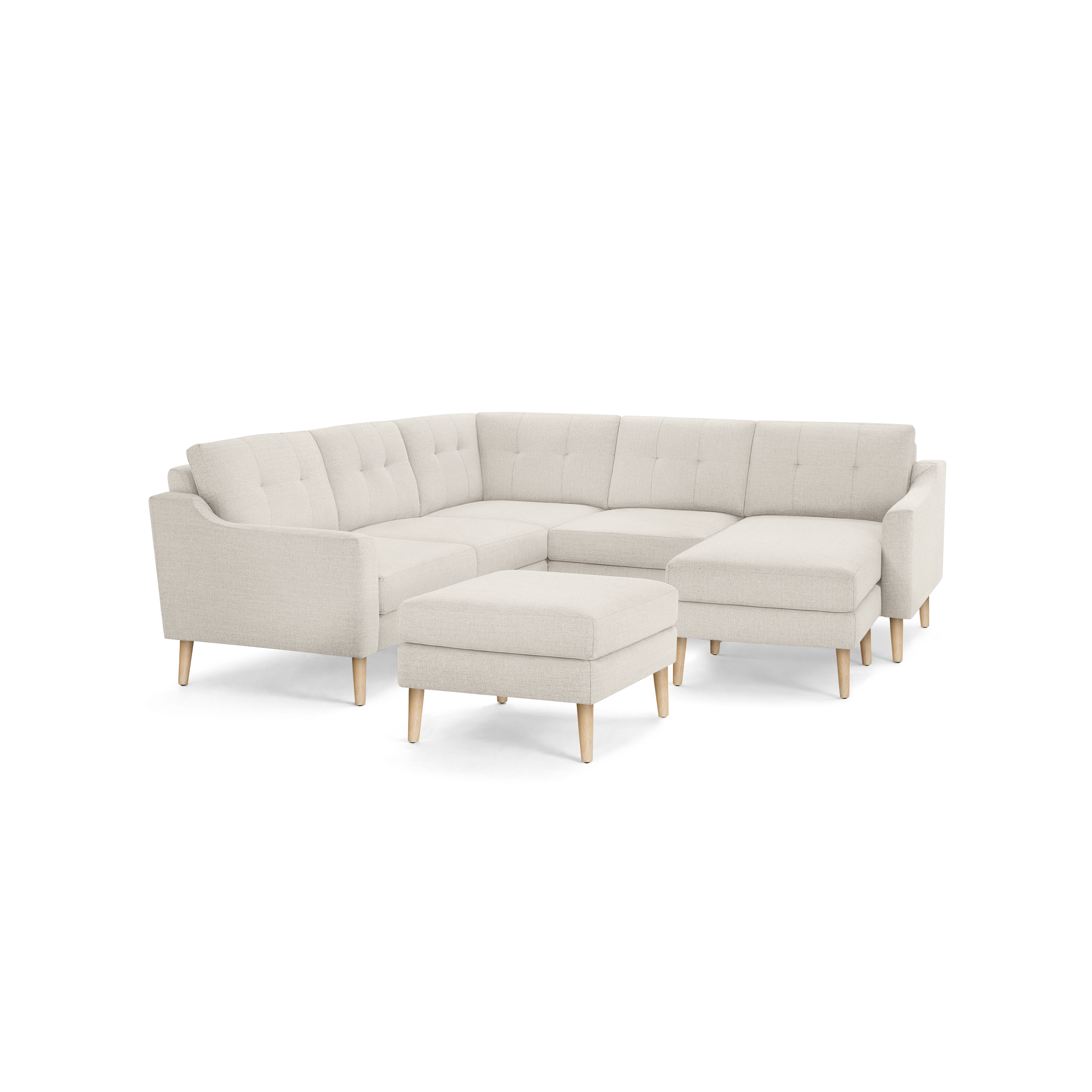 Light beige L-shaped sectional sofa with tufted back cushions, wooden legs, and a matching square ottoman.