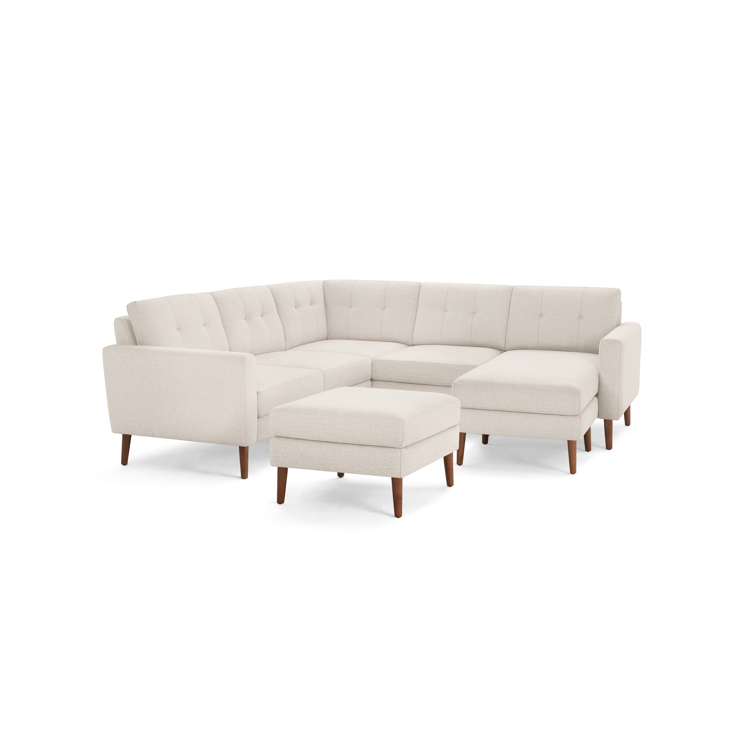 Cream-colored modern sectional sofa with tufted back cushions, wooden legs, and matching cushioned ottoman.