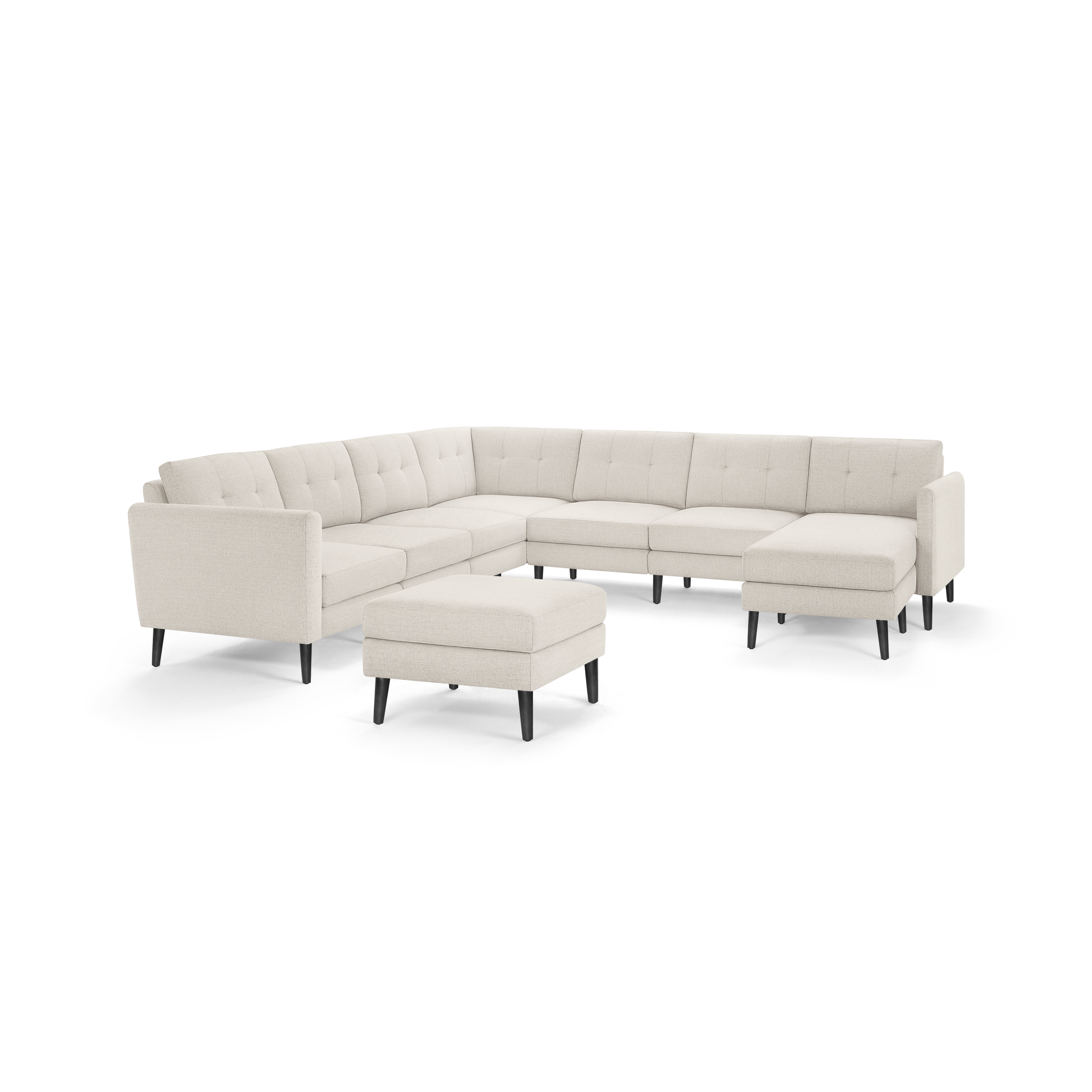 Beige L-shaped sectional sofa with tufted cushions, black tapered legs, and matching ottoman on white background.