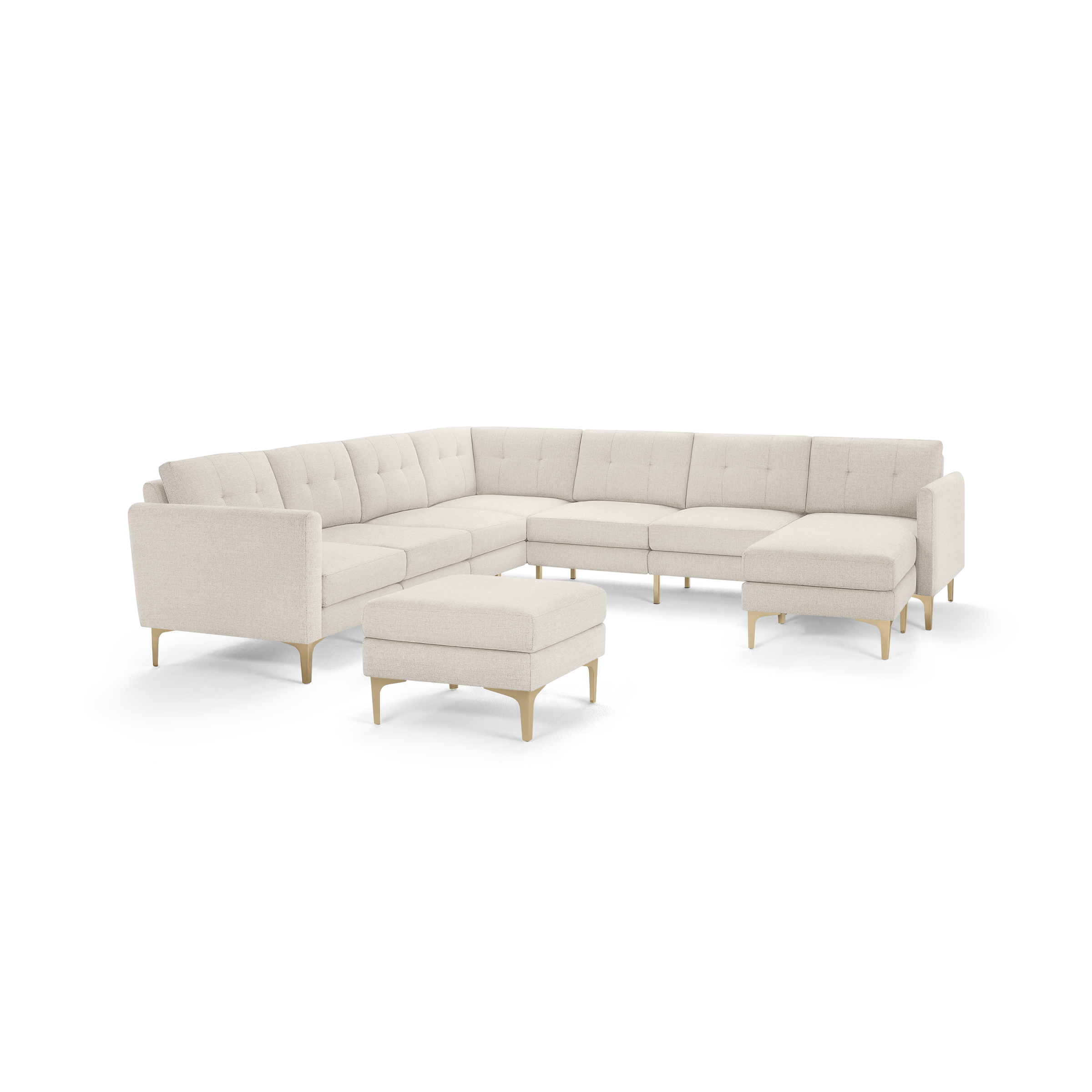 Large beige L-shaped sectional sofa with tufted cushions, wooden legs, and matching ottoman, designed for spacious living rooms.